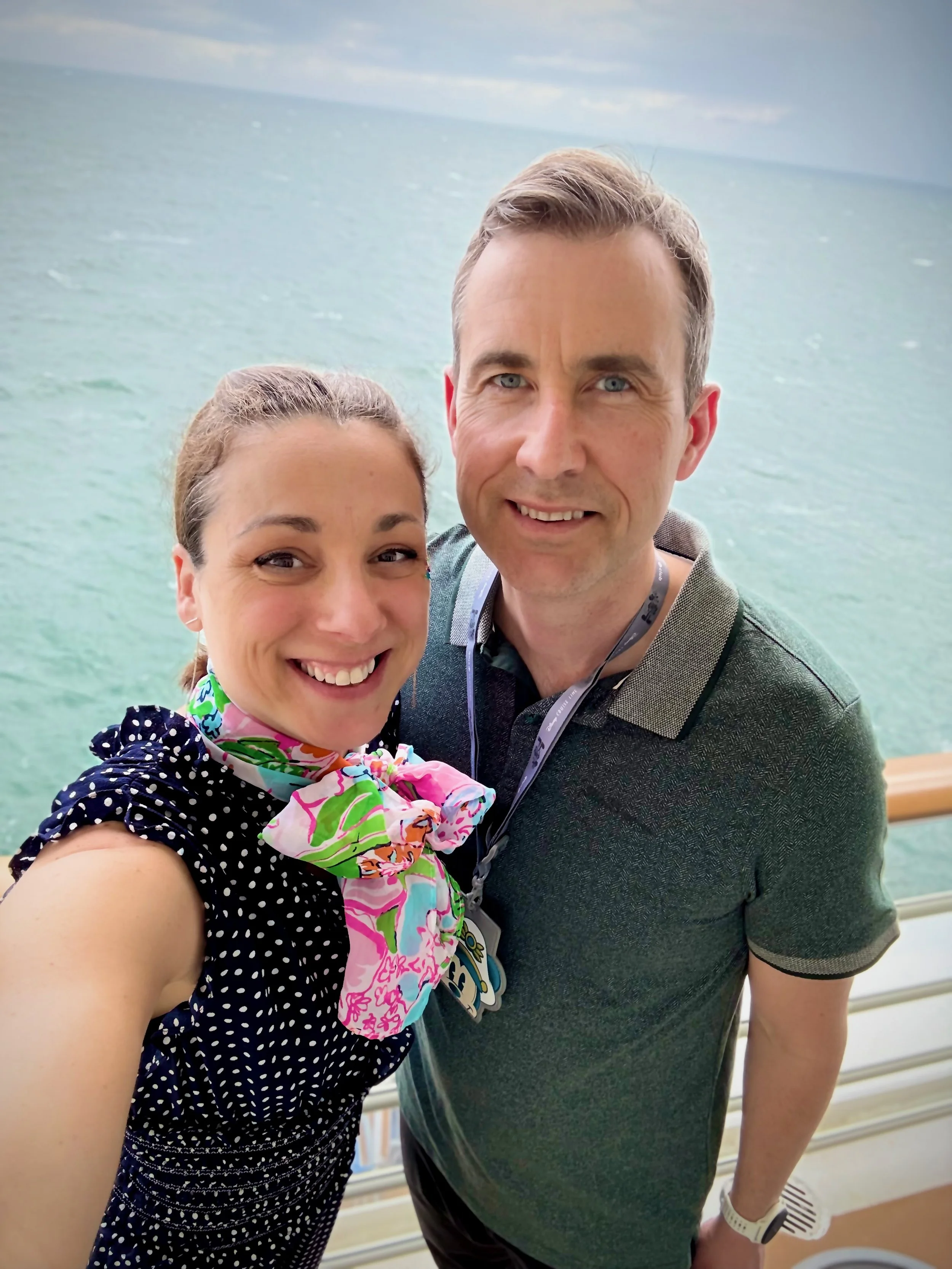 Roberta and her husband taking a selfie on Disney's Fantasy cruise ship balcony with the ocean in the background, heading to Lookout Cay at Lighthouse Point