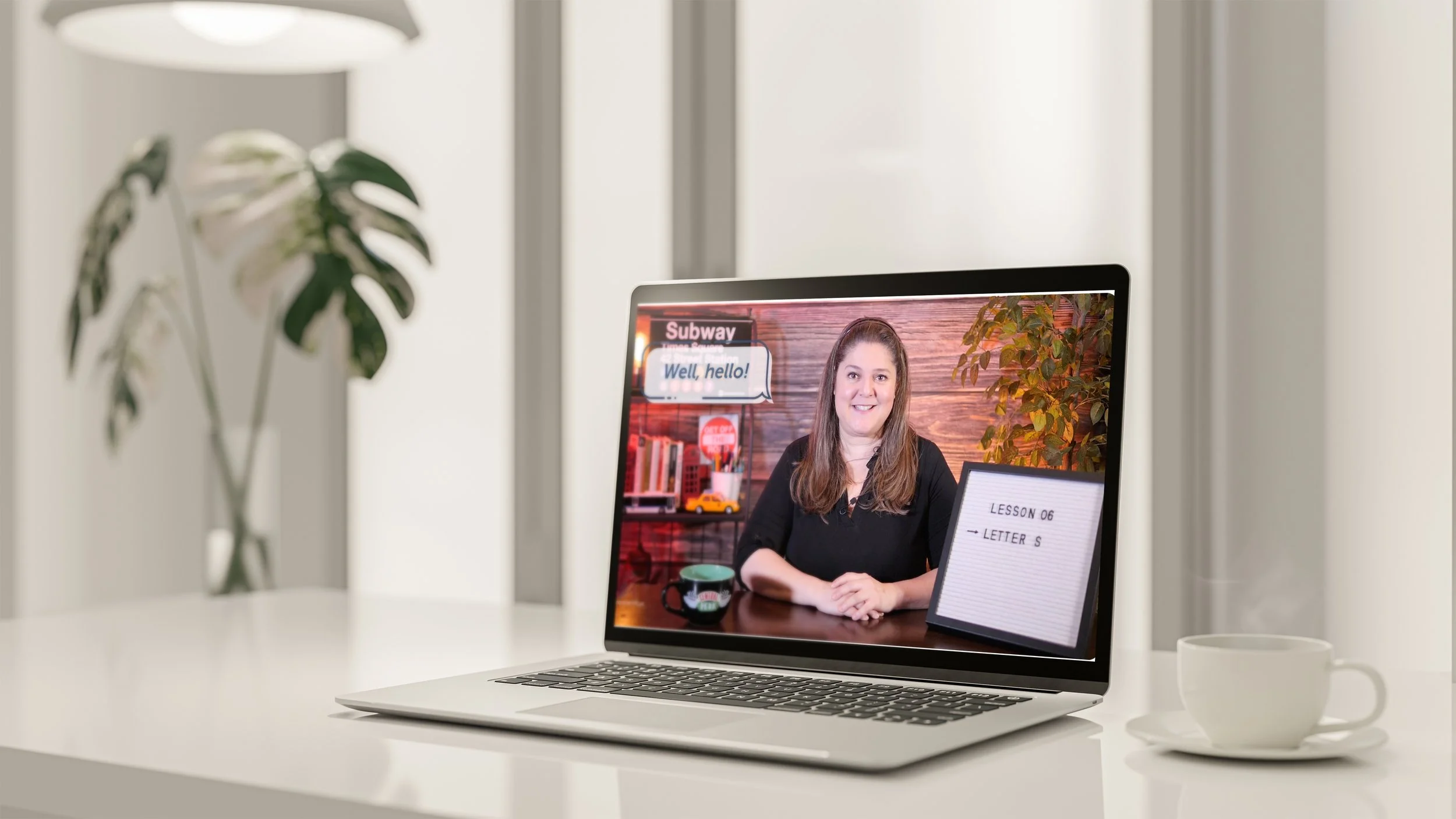 Laptop on a white desk displaying Cris Vieira teaching English online