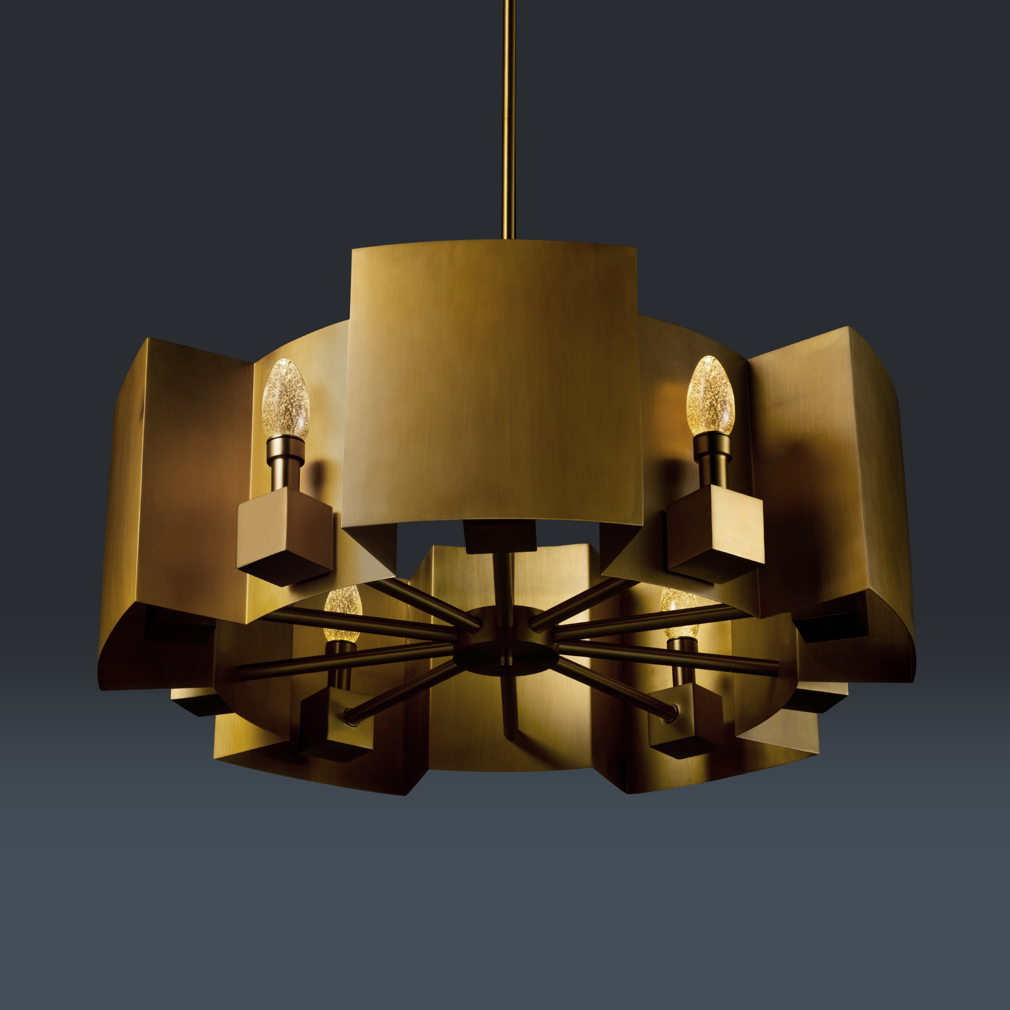 A modern gold chandelier with multiple arms and small light bulbs against a dark background.