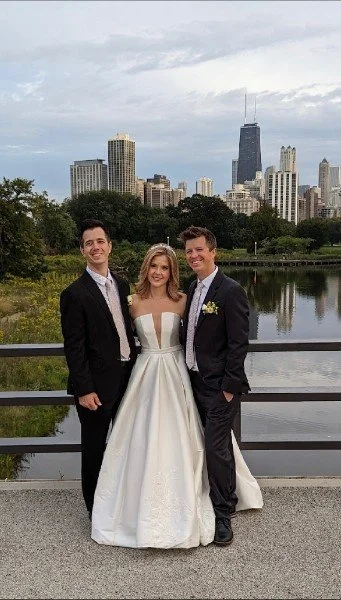 A photo of three people with chicago in the background