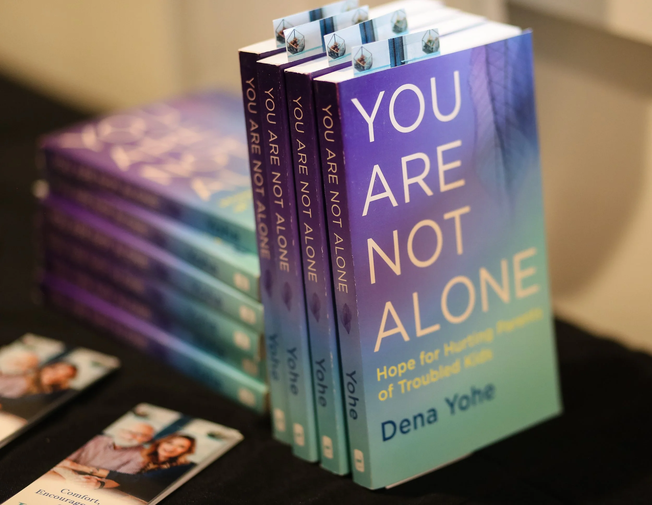 Several copies of "You Are Not Alone," a book by Just Be Held retreat speaker Dena Yohe.