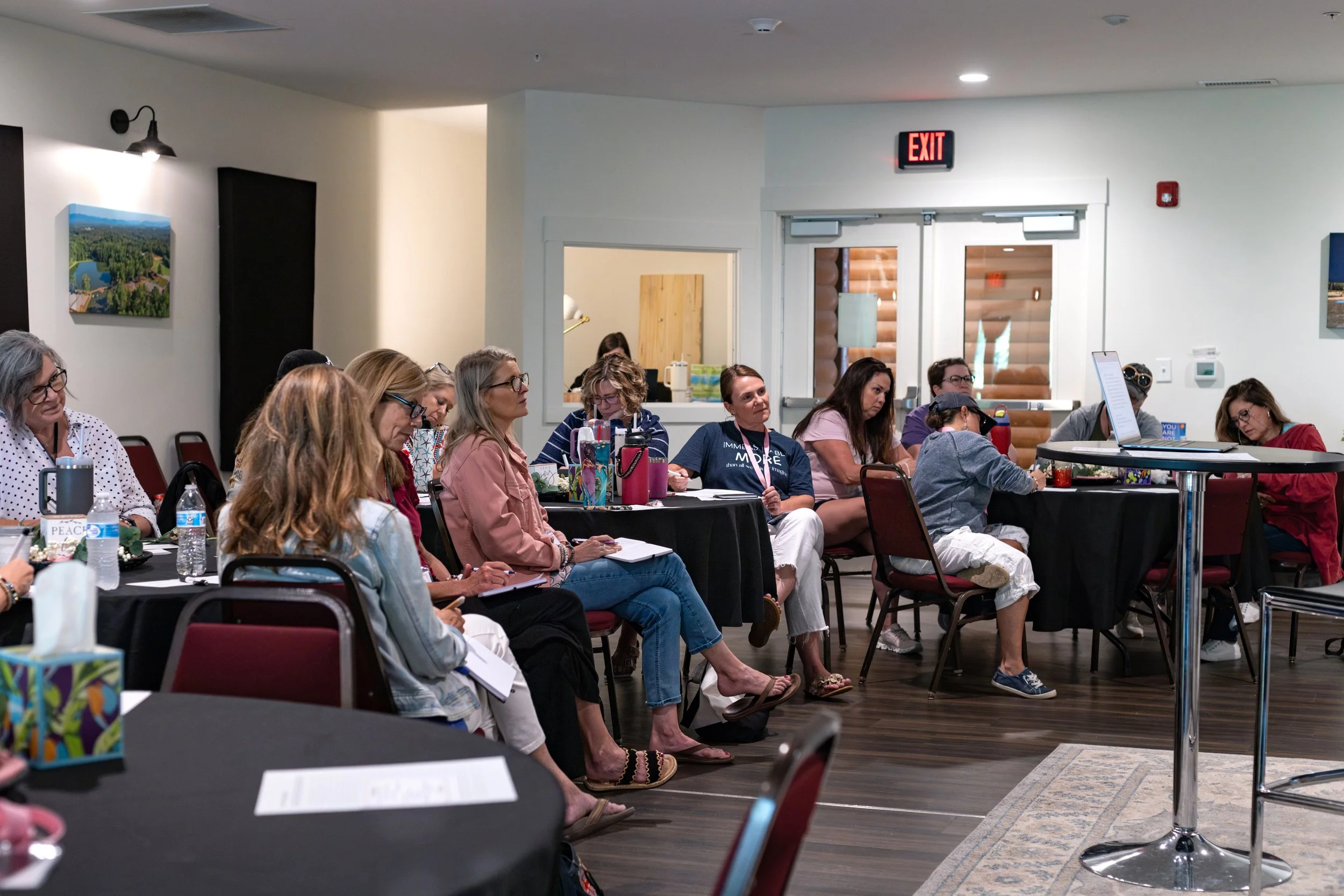 Women sitting in the audience at Just Be Held, listening to the speaker