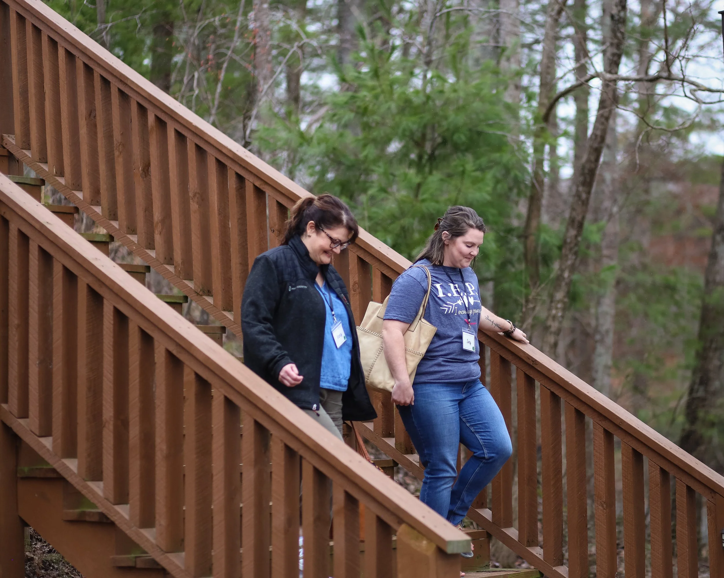 Two women walking down the outside stairs at the Lodge at Woodlands Camp