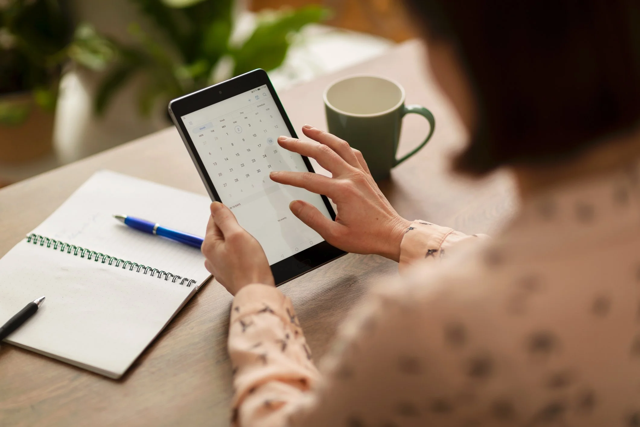 Person using an ipad to schedule an appointment on calendar app