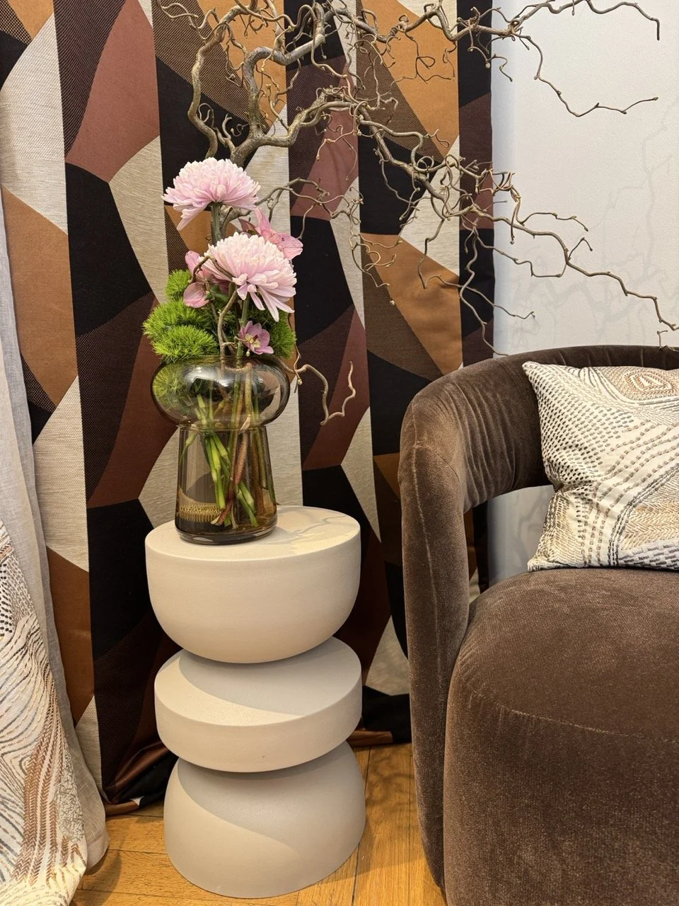 Grüppchen aus Hocker, Blumenvase und Textilien