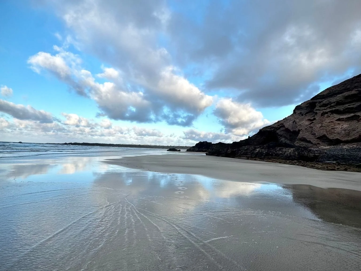 Quiet sandy beach surrounded by volcanic cliffs in north Lanzarote
