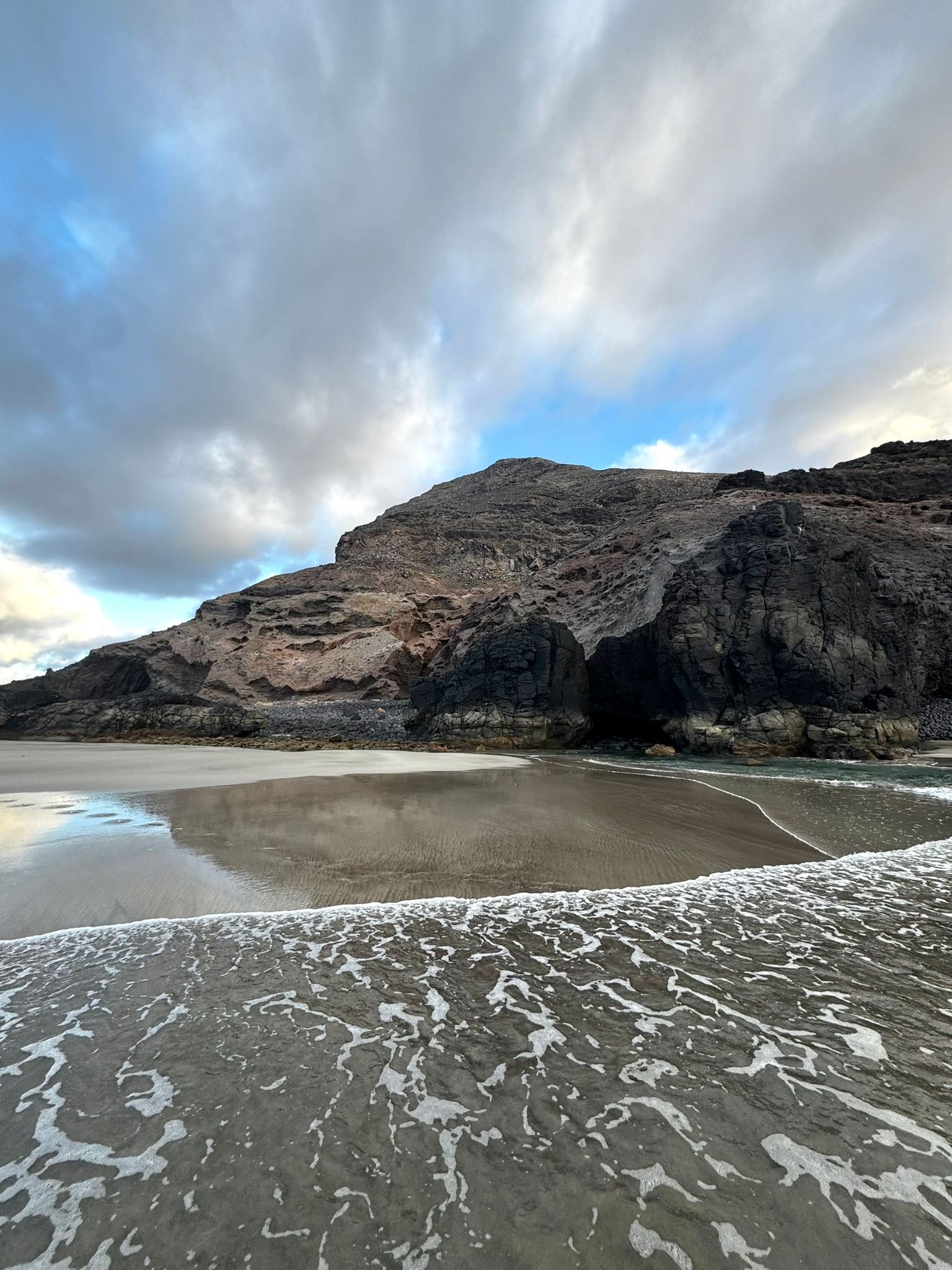 Volcanic sea cave and coastline exposed by low tide in northern Lanzarote.