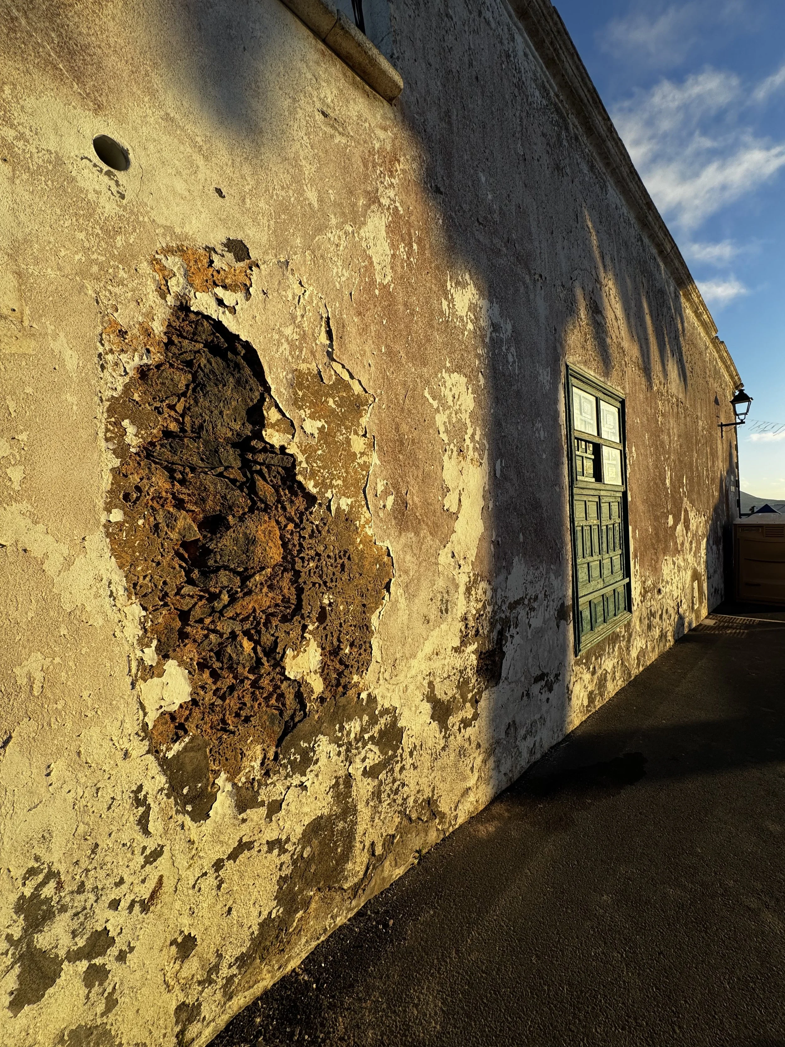 Weathered volcanic stone wall glowing in the evening light in Lanzarote.