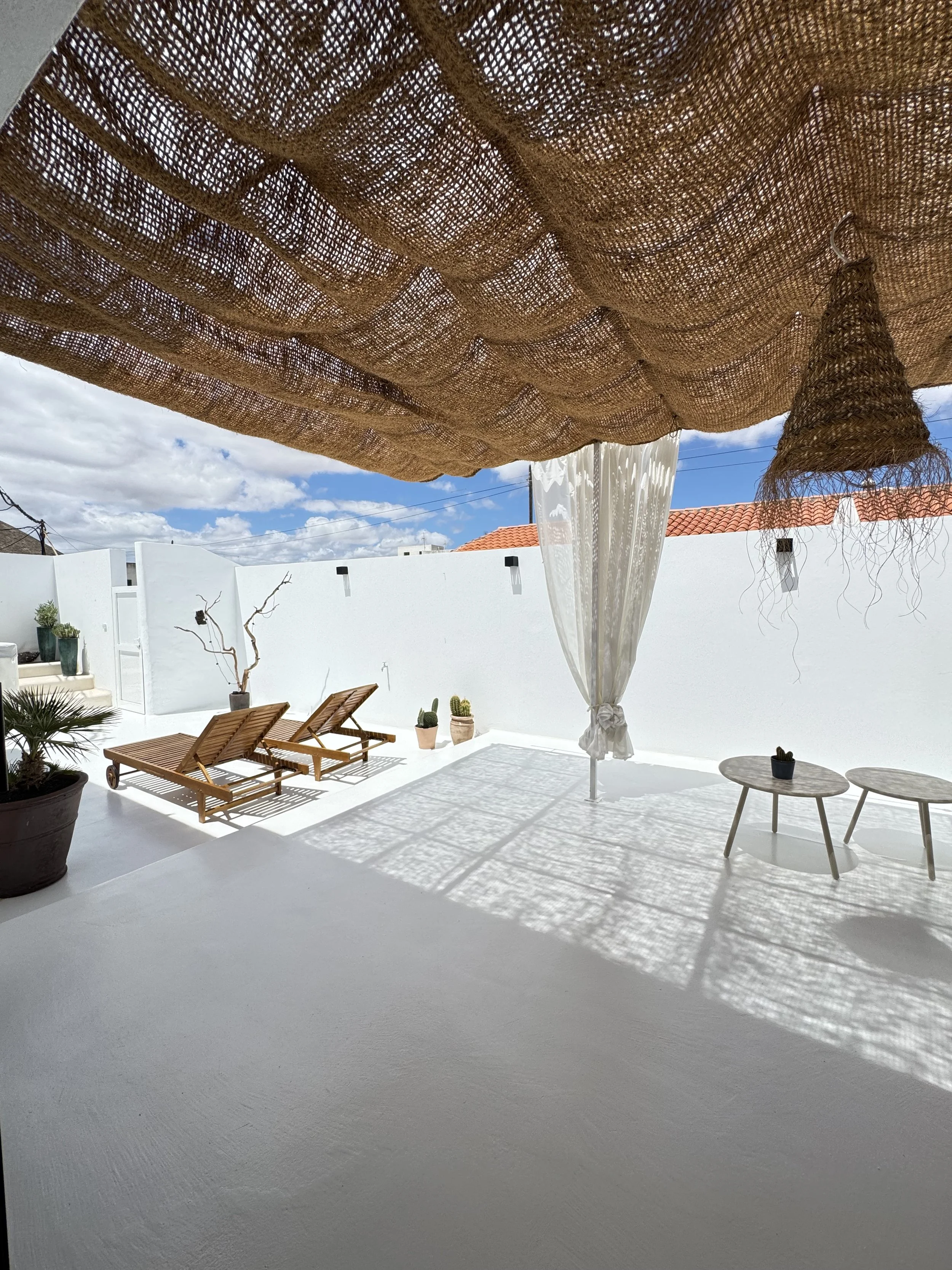 Private terrace with woven pergola shadows and wooden loungers at Casita Luna Lanzarote