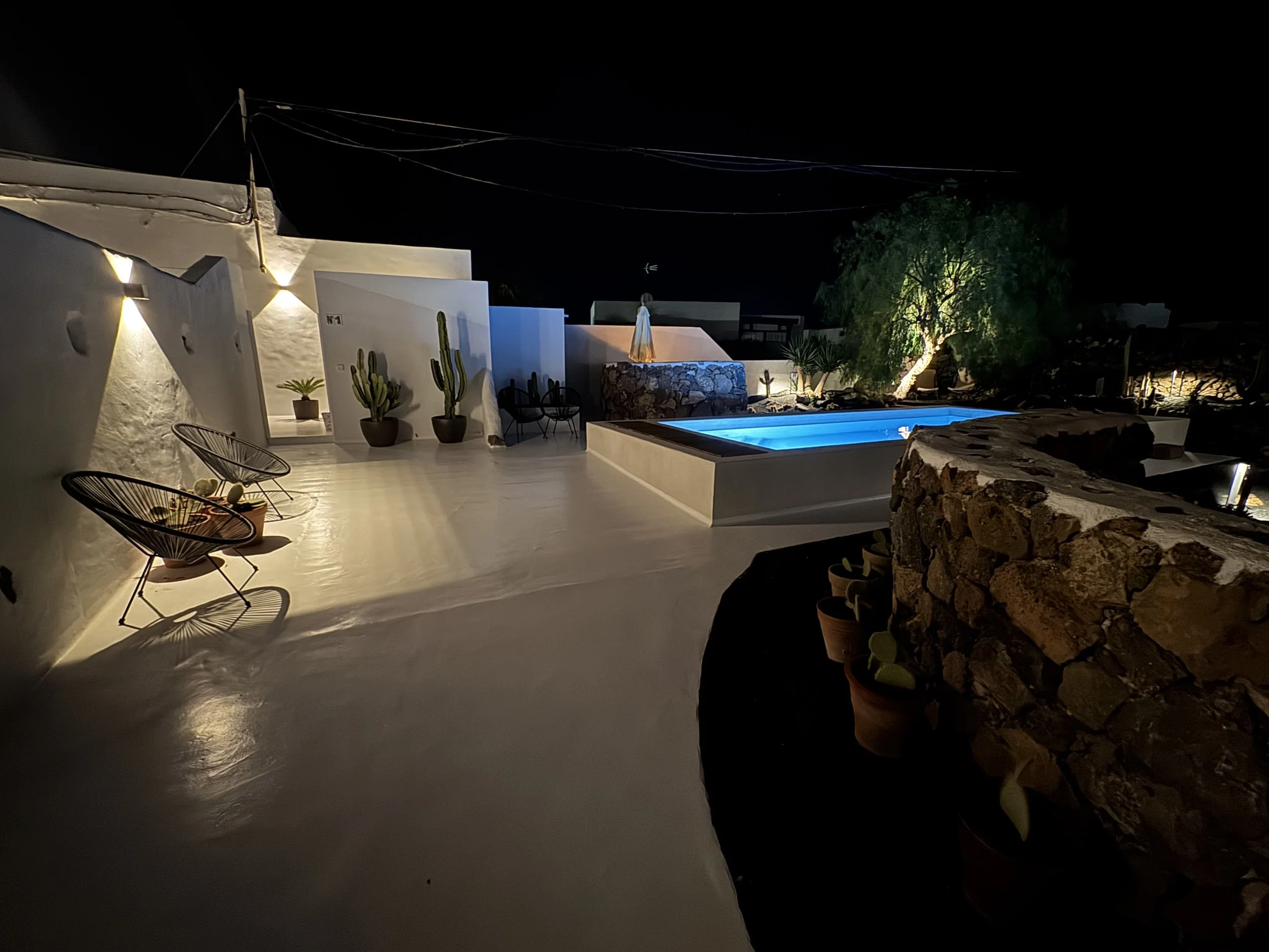 Night poolscape with volcanic garden and loungers at Casitas Santa Rita Lanzarote