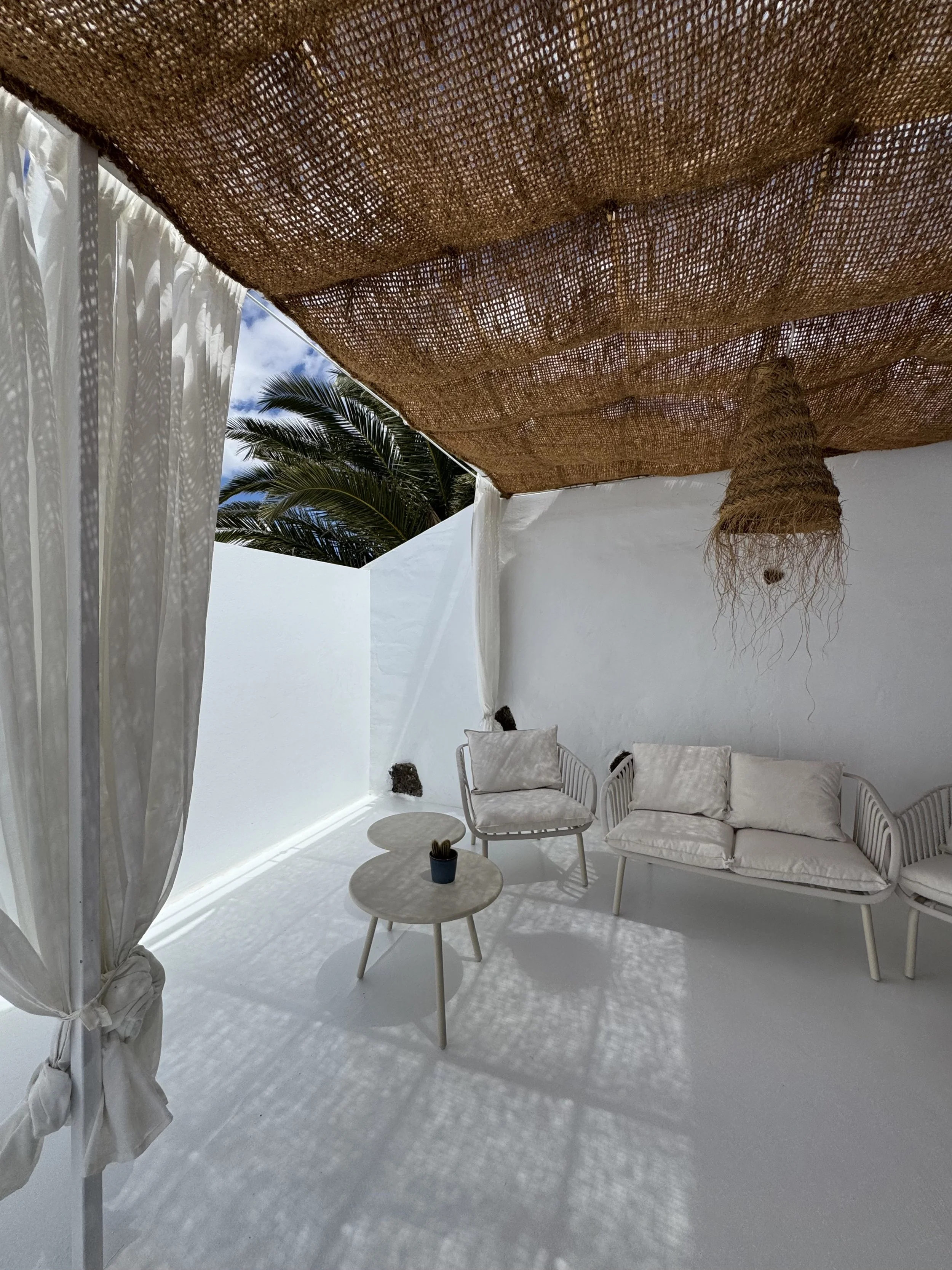 Covered terrace lounge with natural shadows and white seating at Casita Luna Lanzarote