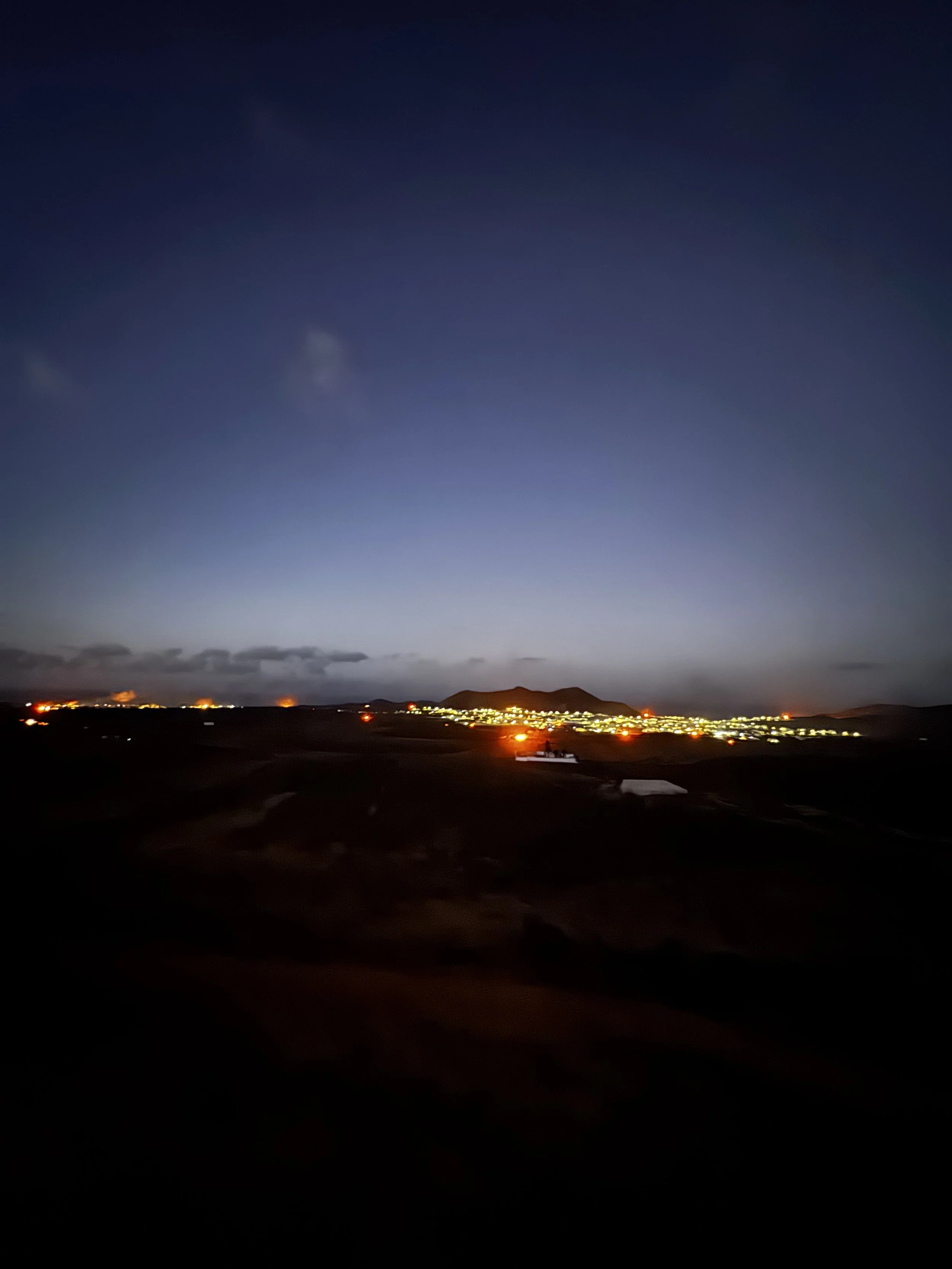 Bonfires begin appearing across Lanzarote as darkness falls on the night of San Juan.