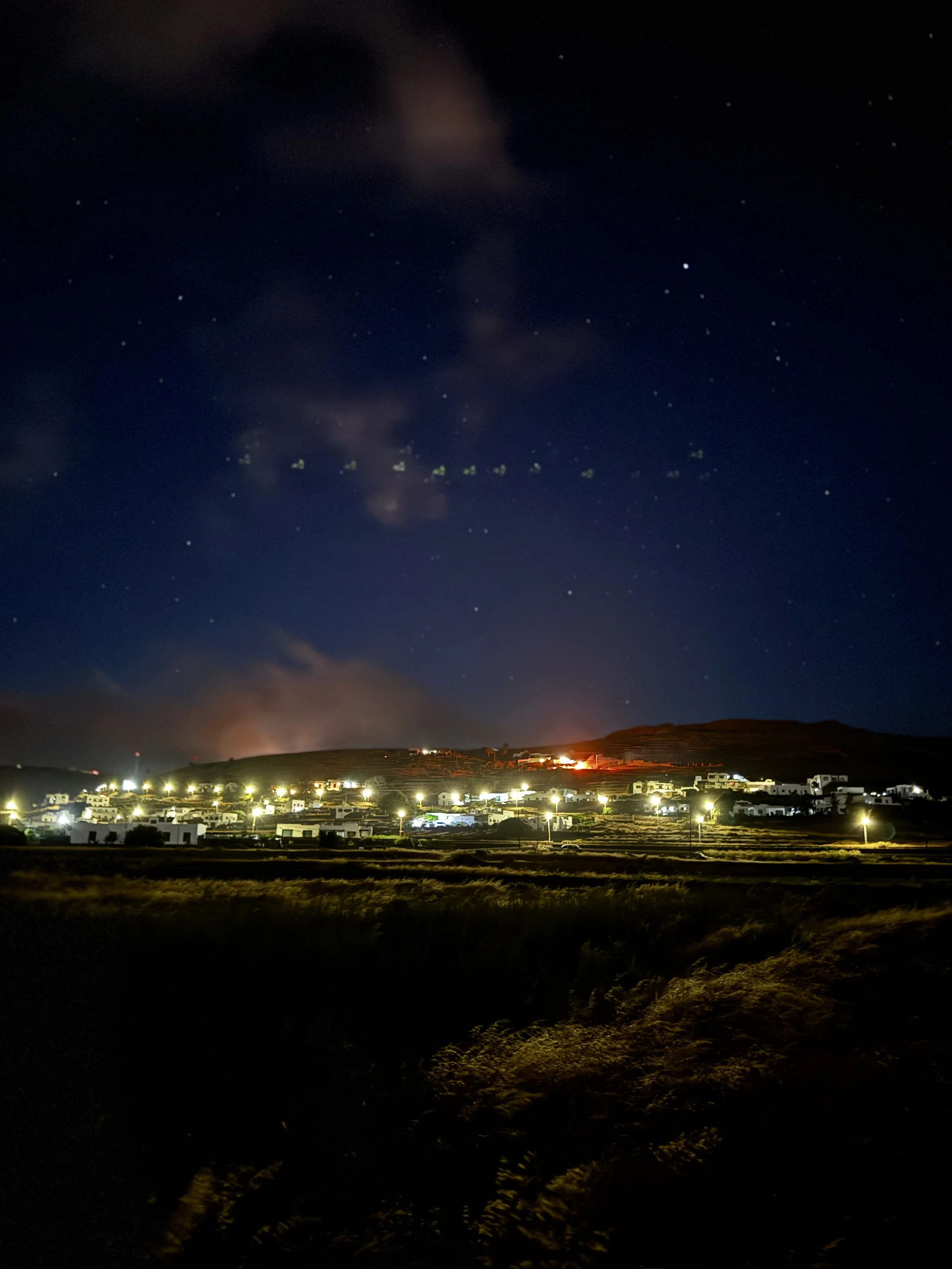 From the hills of northern Lanzarote, fires appear like stars scattered across the landscape.