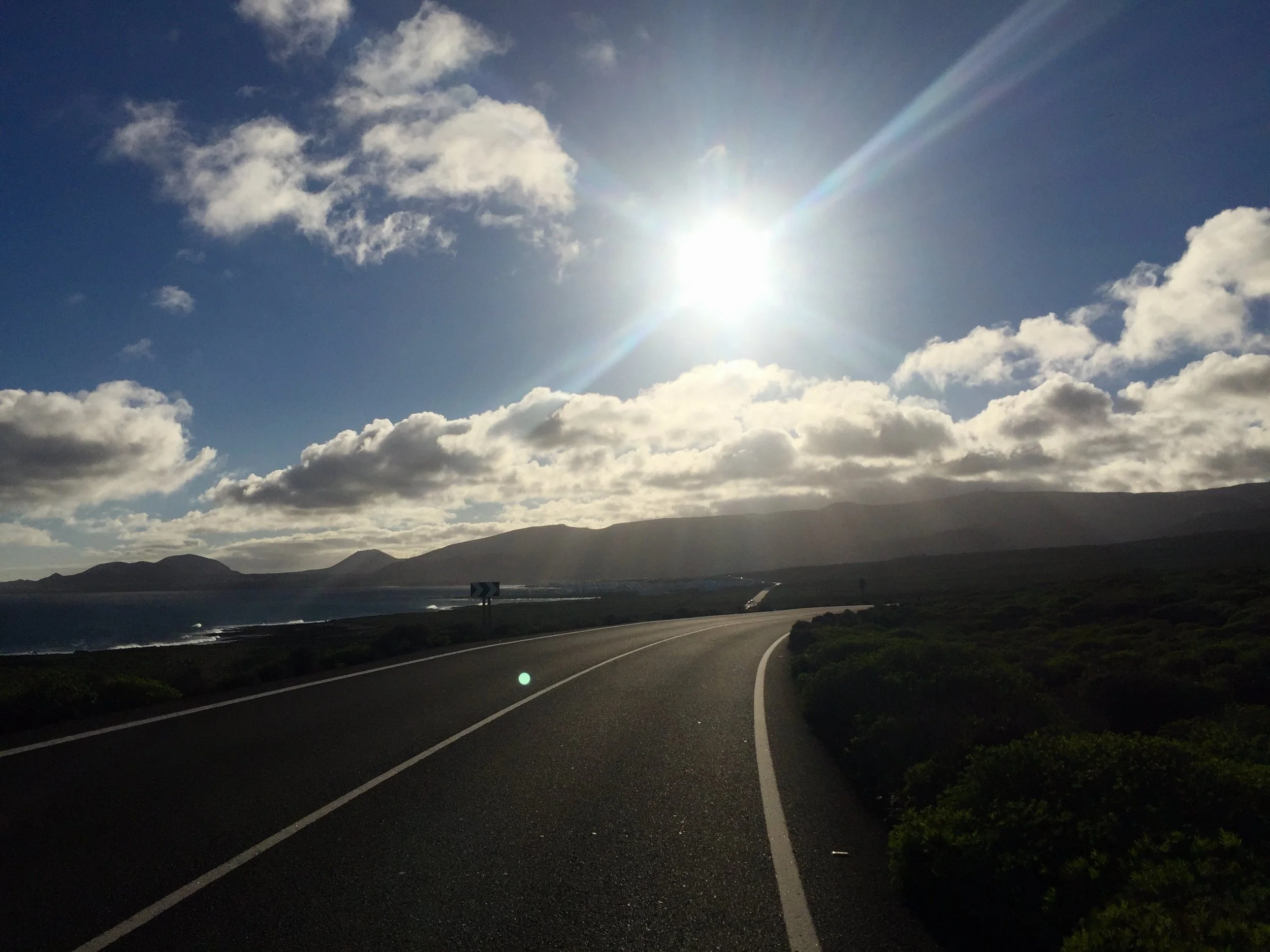 Coastal road through the volcanic landscape of northern Lanzarote under a bright winter sun