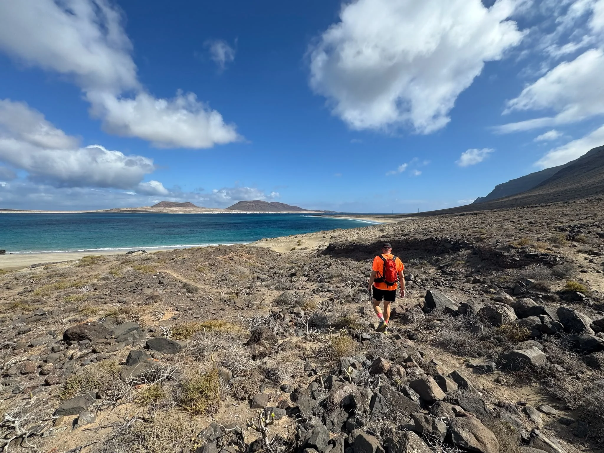 Hiker walking along Camino de los Gracioseros above Playa del Risco, Lanzarote