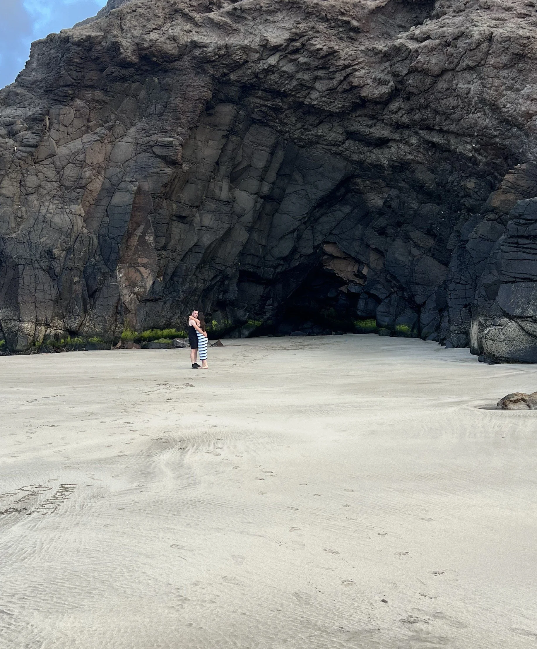Couple embracing inside a hidden sea cave revealed by an extraordinary low tide at Playa de Las Canteras in Lanzarote.