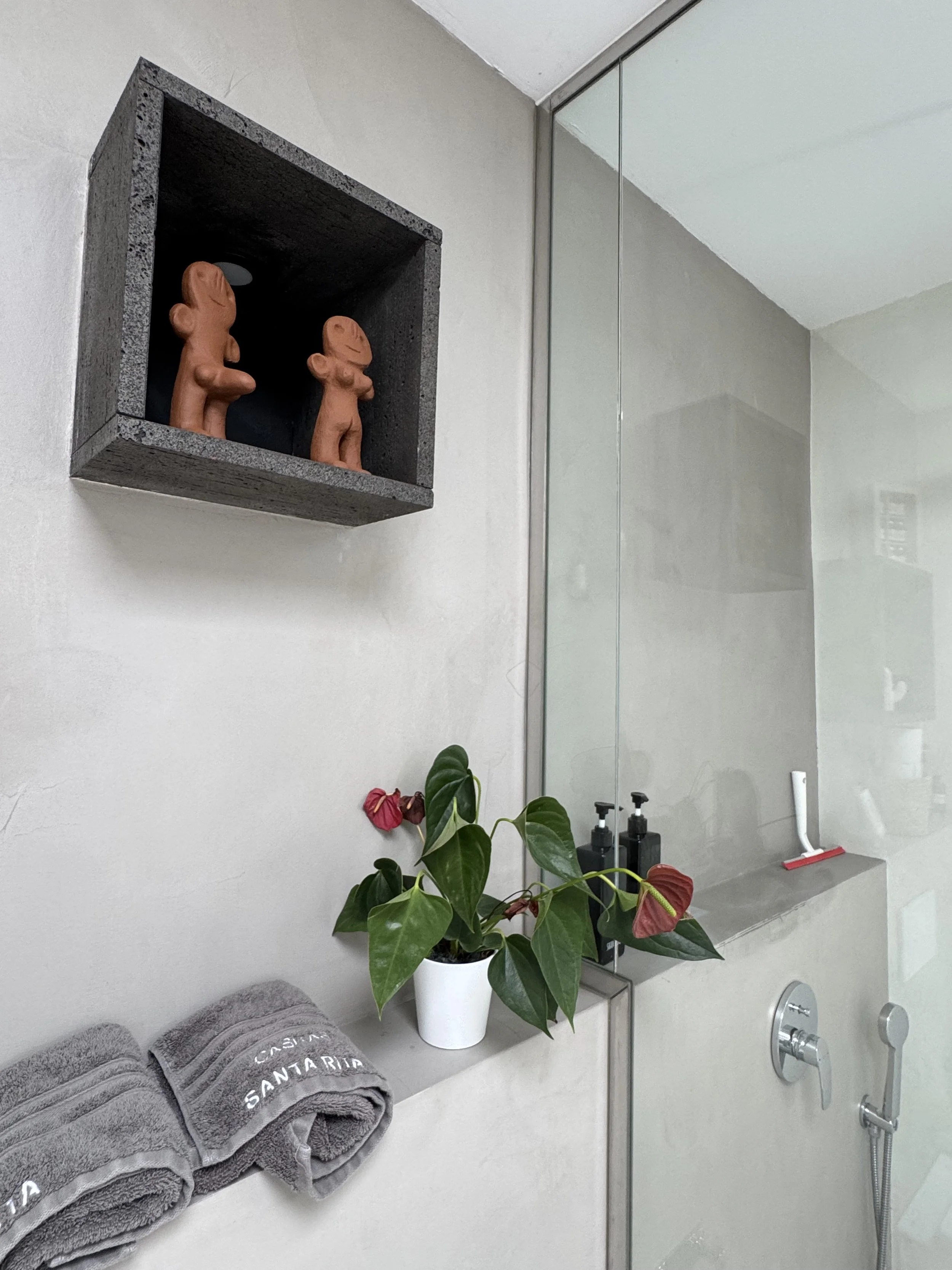 Bathroom decor detail with artisan figures and tropical plant at Casita Luna Lanzarote