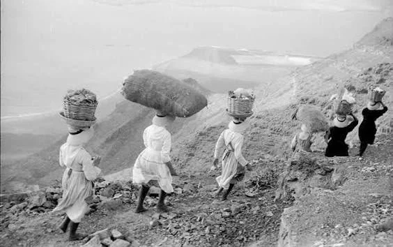Women from La Graciosa carrying baskets and bundles along the Camino de los Gracioseros.