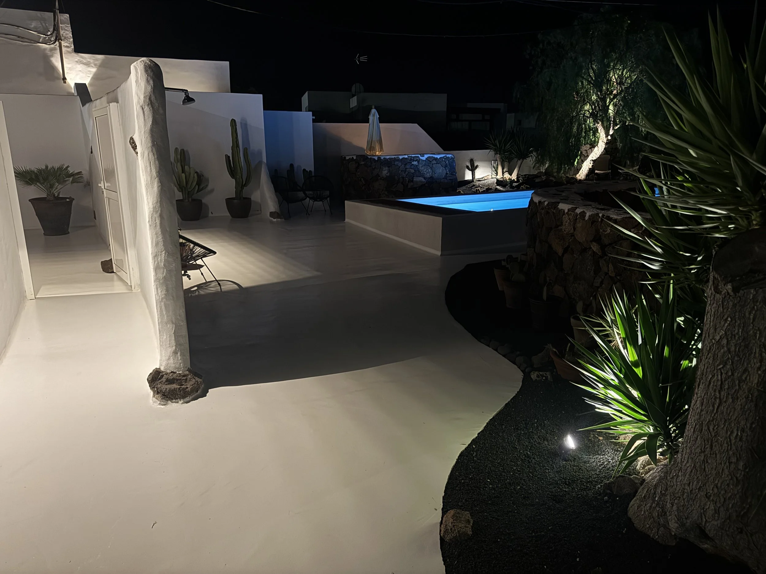 Night poolscape with volcanic garden and loungers at Casitas Santa Rita Lanzarote