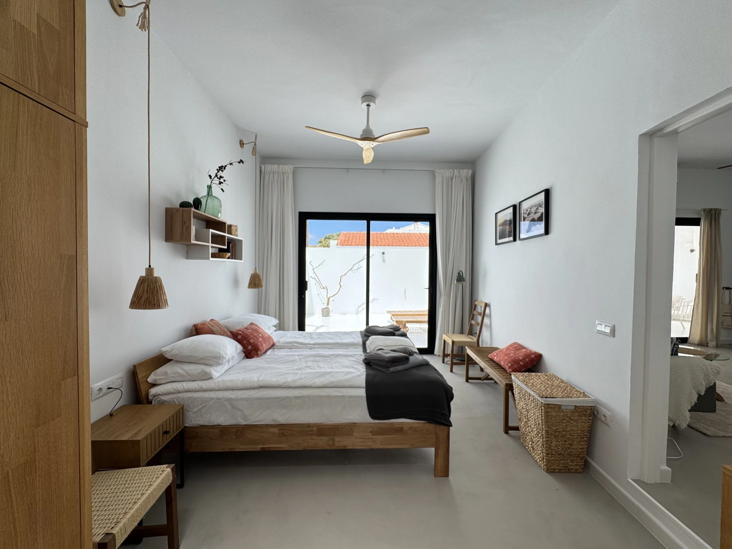 Minimalist bedroom with natural wood furniture and terrace view at Casita Luna Lanzarote