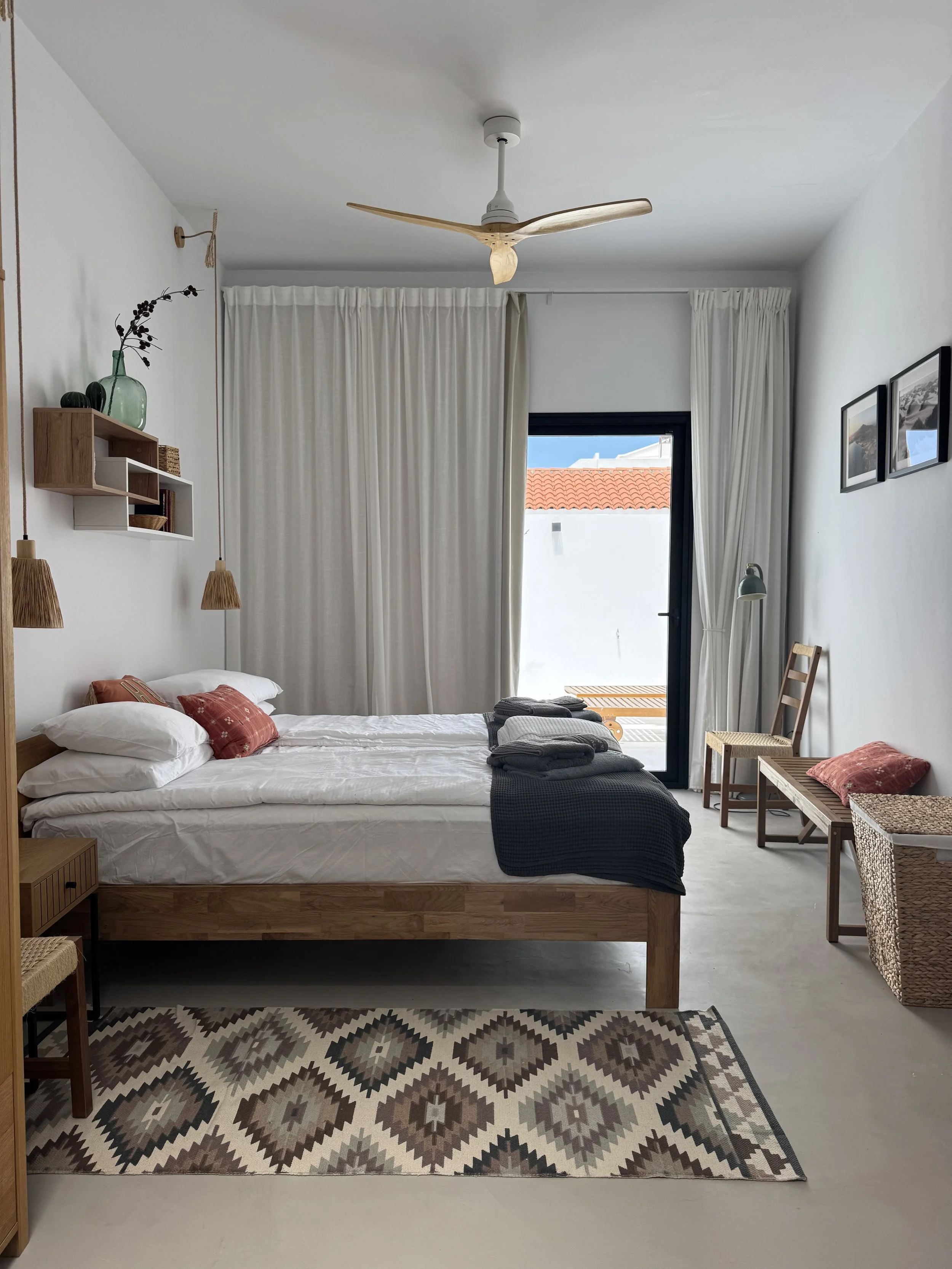 Minimalist bedroom with terrace access and calm island atmosphere at Casita Luna Lanzarote