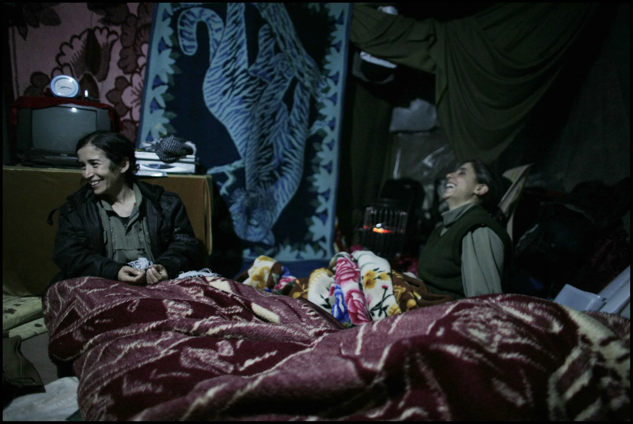 PJAK Qandil mountains, Kurdistan.
The nights are cold but the blankets warm.
Two PJAK members share a joke in the purpose built cave structure where the women sleep.