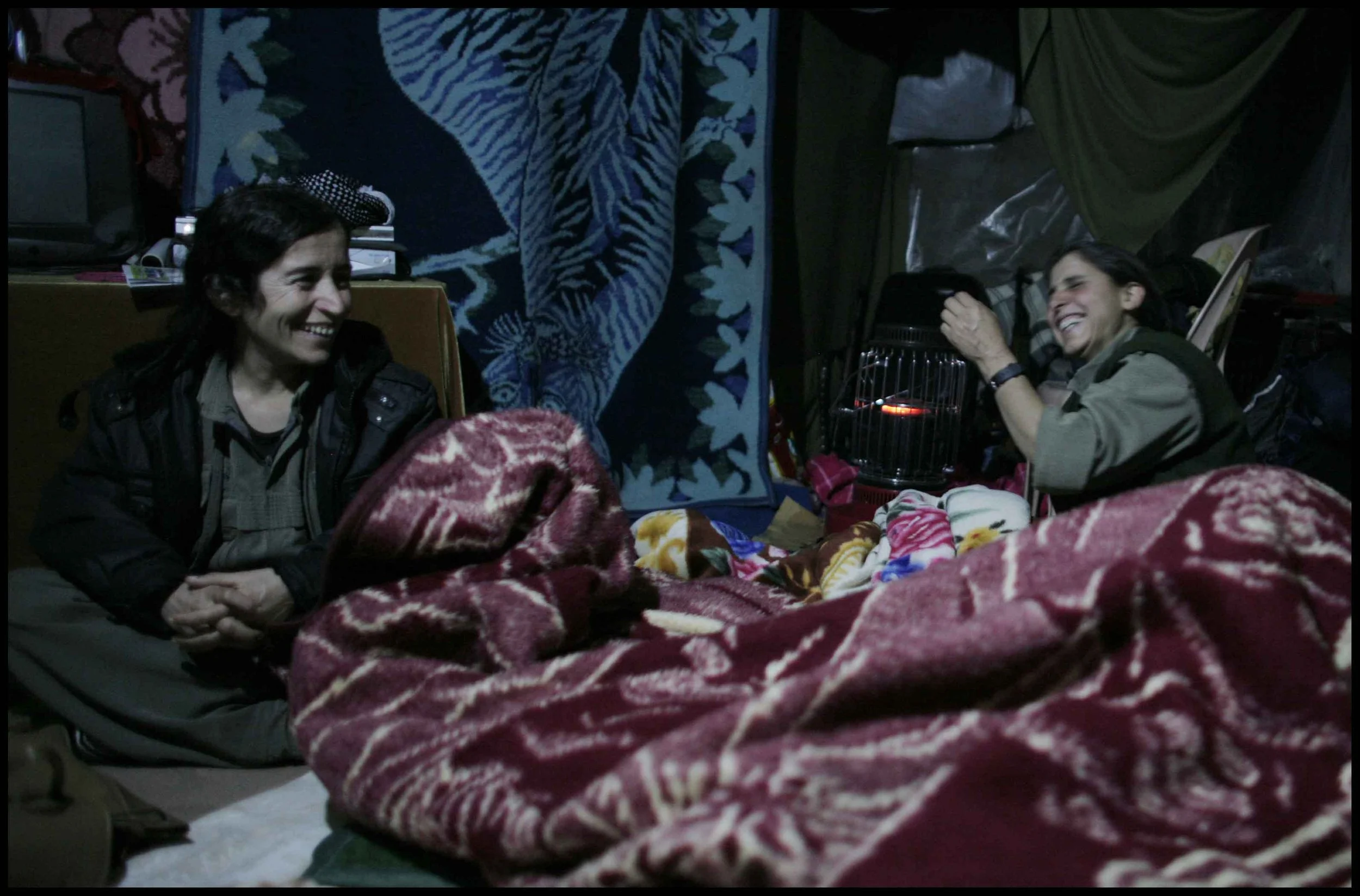 PJAK Qandil mountains, Kurdistan.
The nights are cold but the blankets warm.
Two PJAK members share a joke in the purpose built cave structure where the women sleep.
