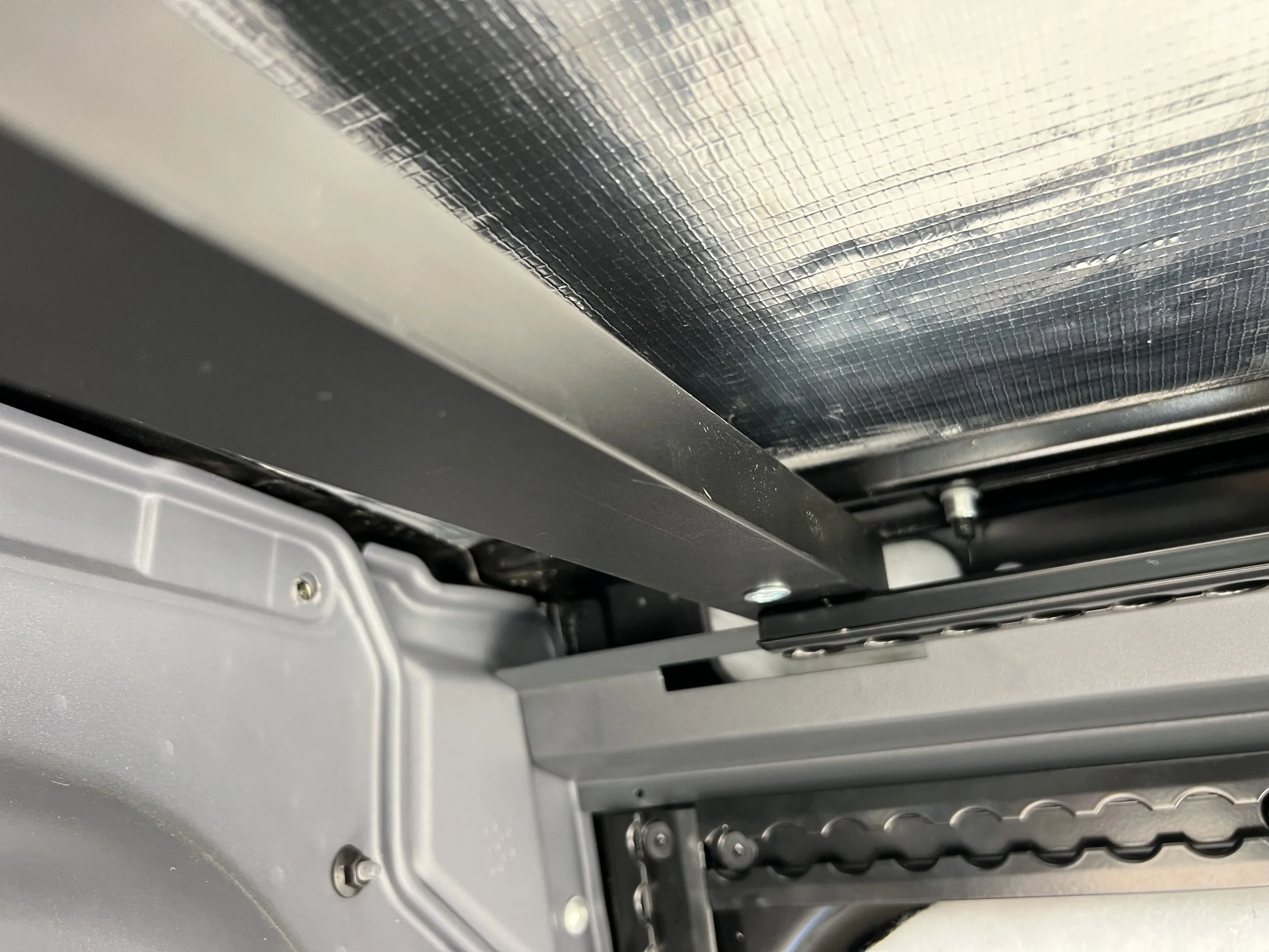 Close-up of a metal frame and chain mechanism inside a machine or device.