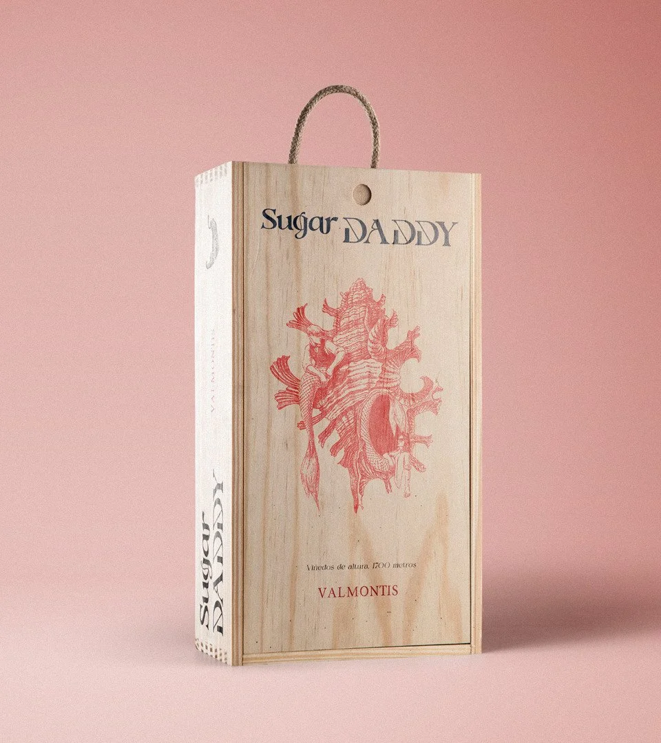 Mockup of wooden box “Sugar DADDY” by Daniel Perez Cabrera: wine packaging concept engraved with ink illustration of Chicoreus brevifrons shell, triton, and mermaid, vintage-inspired design for speculative rosé wine.