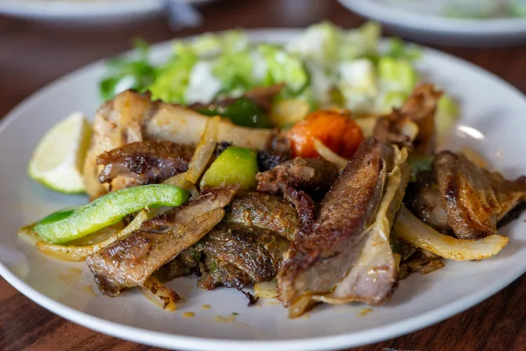 Plate of grilled meat, vegetables, and salad.