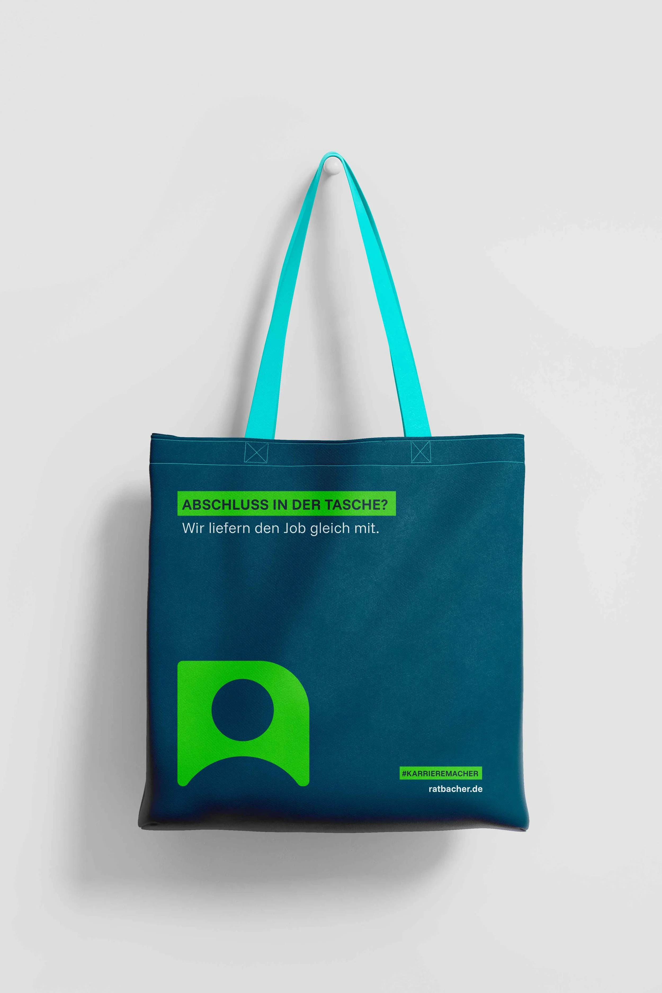 Ein blaue Tasche mit grünen Akzenten, die an einer weißen Wand hängt, mit Text auf der Tasche, der auf eine schnelle Jobvermittlung verweist.