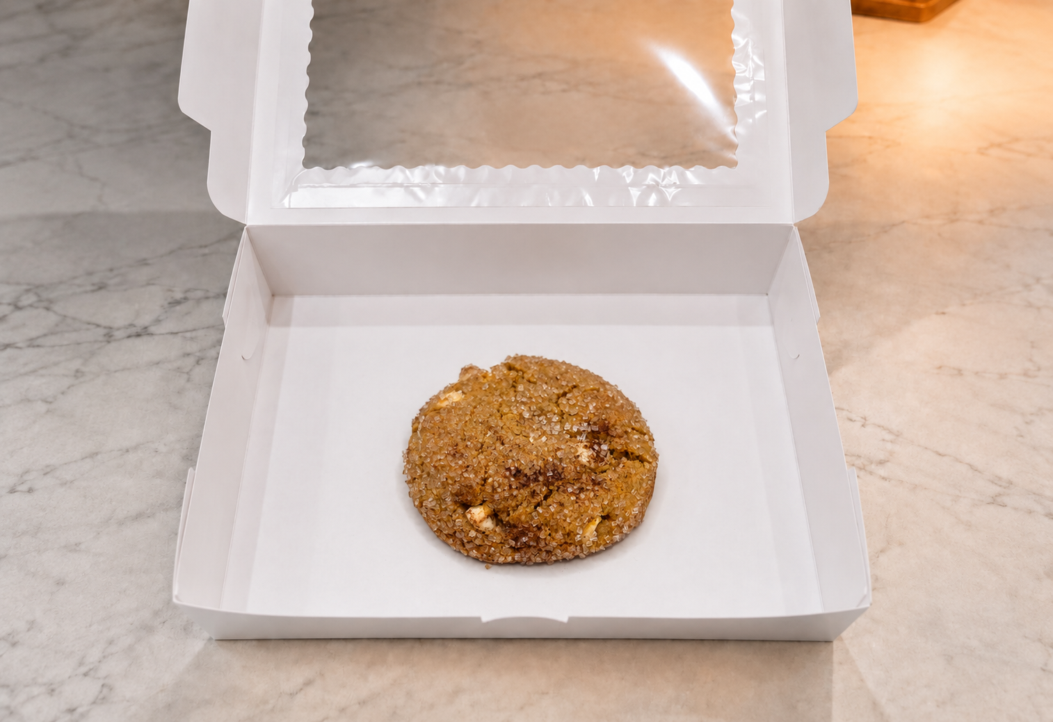 Pumpkin spice cookie with coarse sugar and white chocolate centered in an open white Build-A-Box bakery box