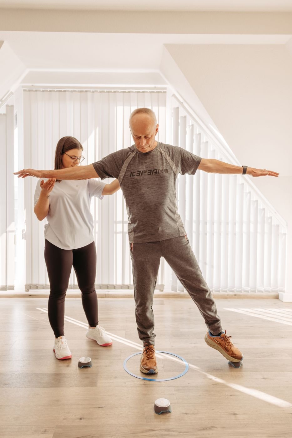 Patient trainiert sein Gleichgewicht mit Ergotherapeutin in der Praxis für Ergotherapie Susann Thieme in Plauen.