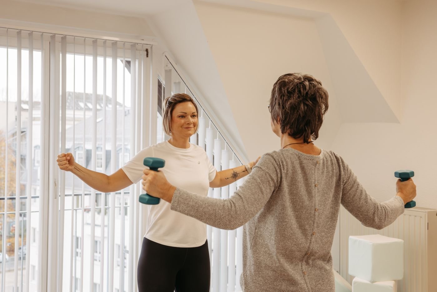 Kräftigungstraining mit zwei Hanteln in der Ergotherapie Susann Thieme in Plauen.