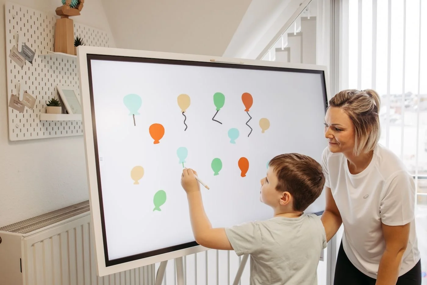 Kinderergotherapie an einer digitalen Übungstafel in der Ergotherapie Susann Thieme in Plauen.