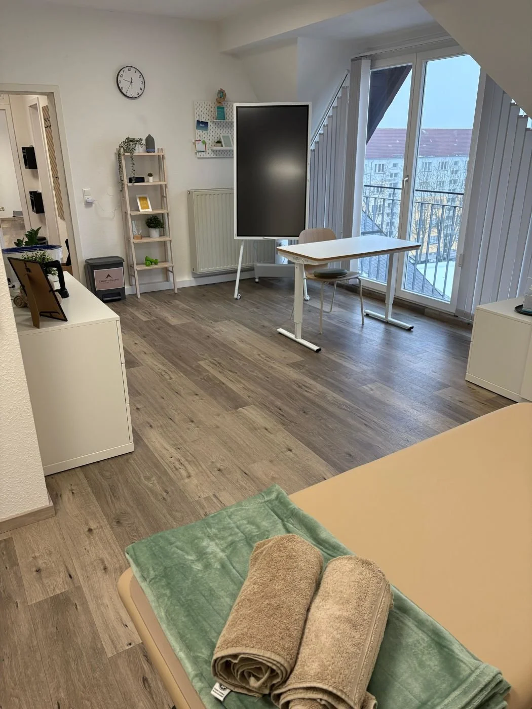 Behandlungszimmer mit Therapieliege, Behandlungstisch und interaktiver Übungstafel in der Praxis für Ergotherapie Susann Thieme in Plauen.