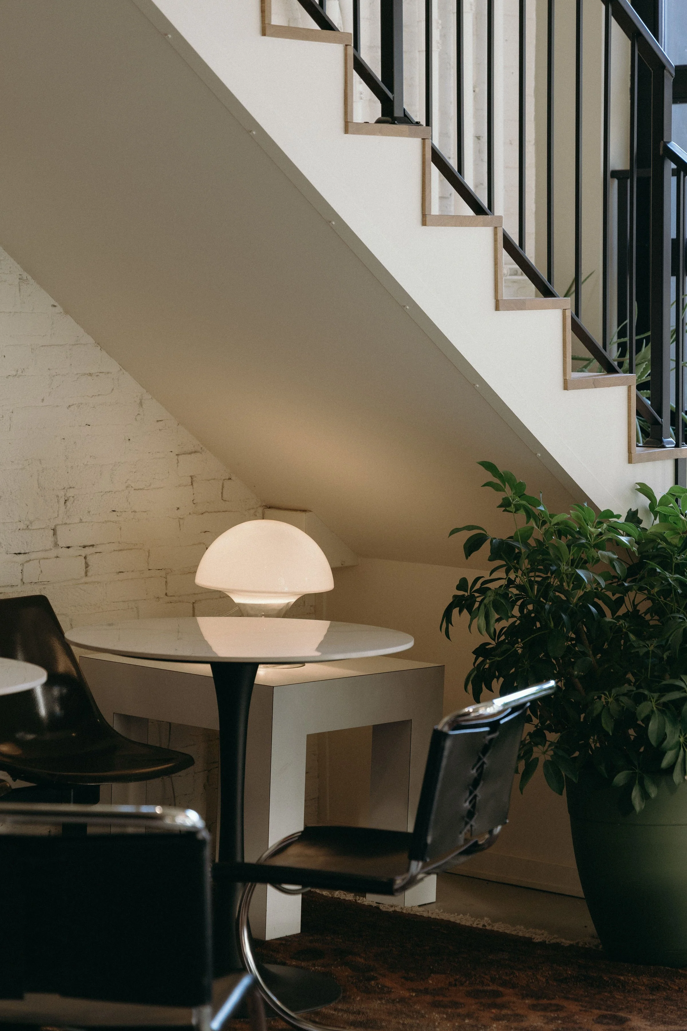 Table with black leather chairs and mushroom lamp.