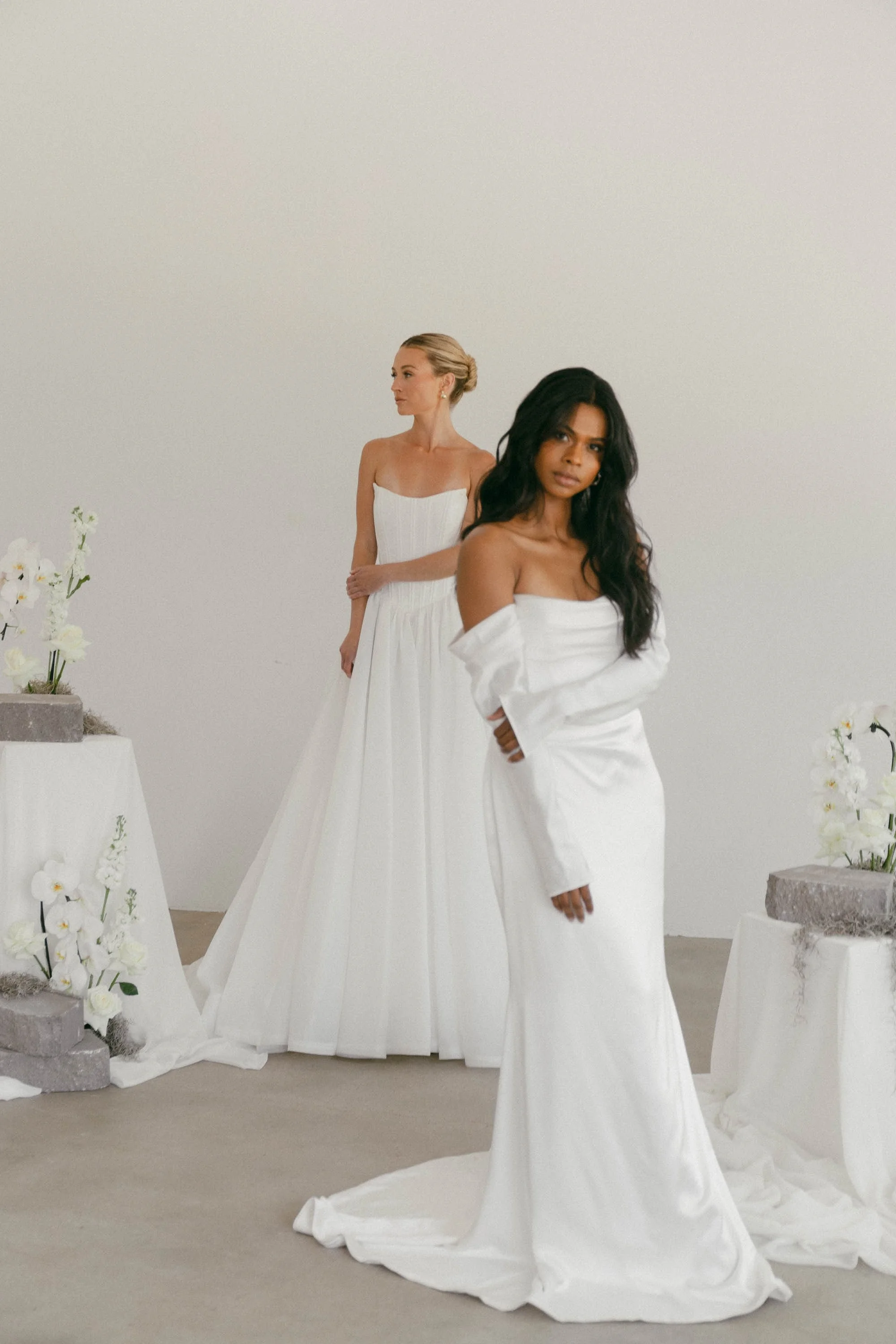 Two women in wedding dresses for bridal boutique.