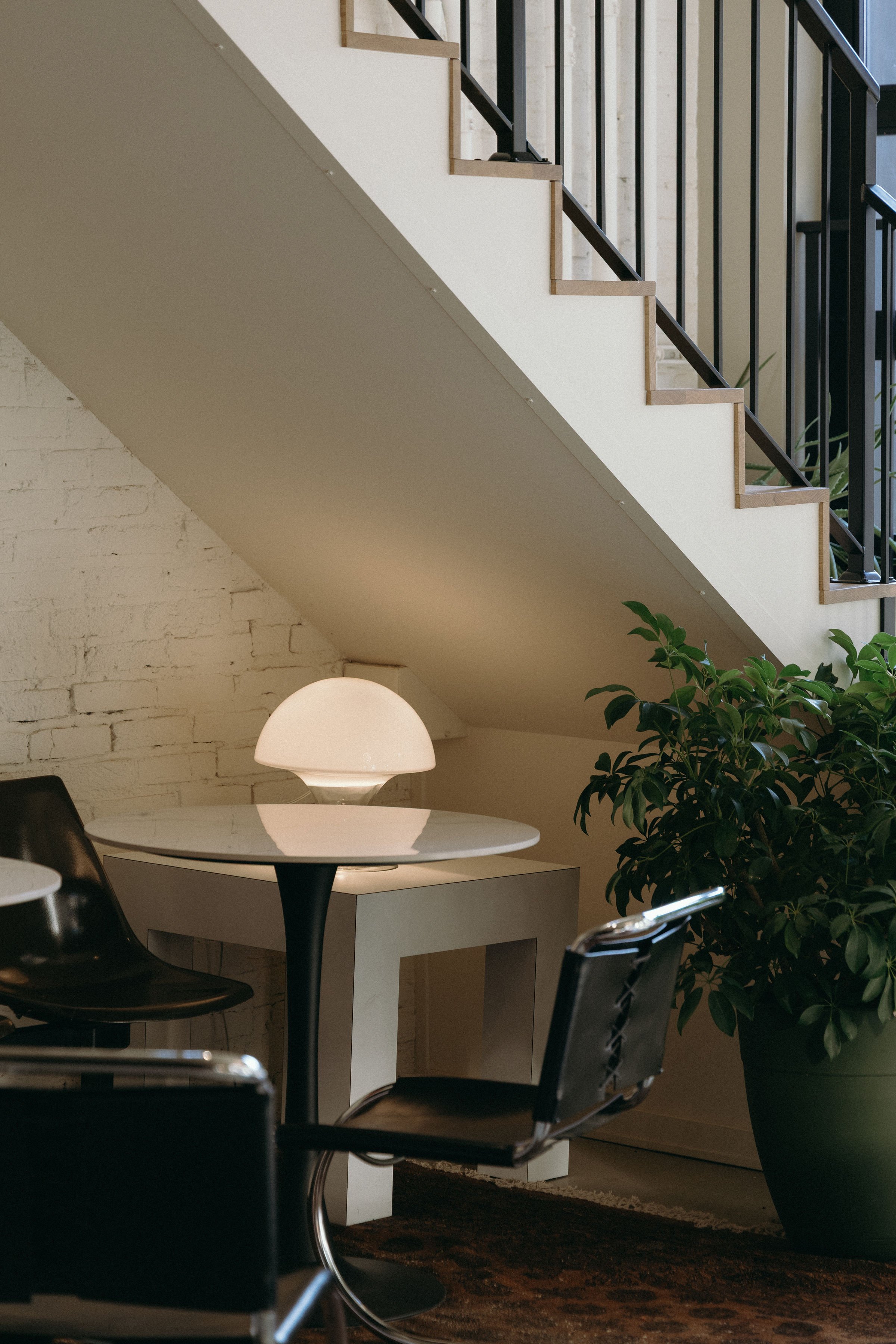 Table with black leather chairs and mushroom light.