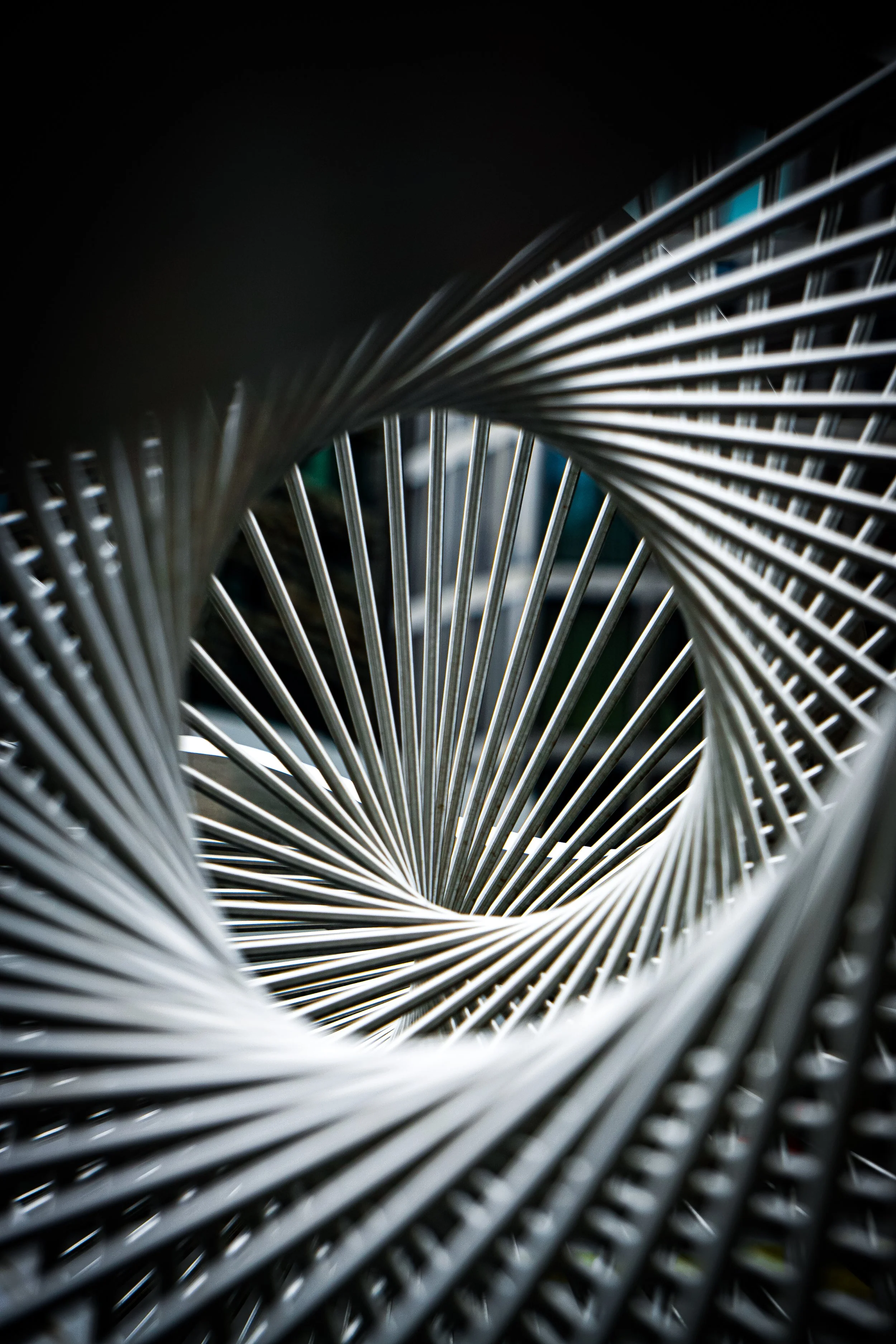 Close-up of a metallic spiral staircase viewed from above, showing the curved steps and railings.