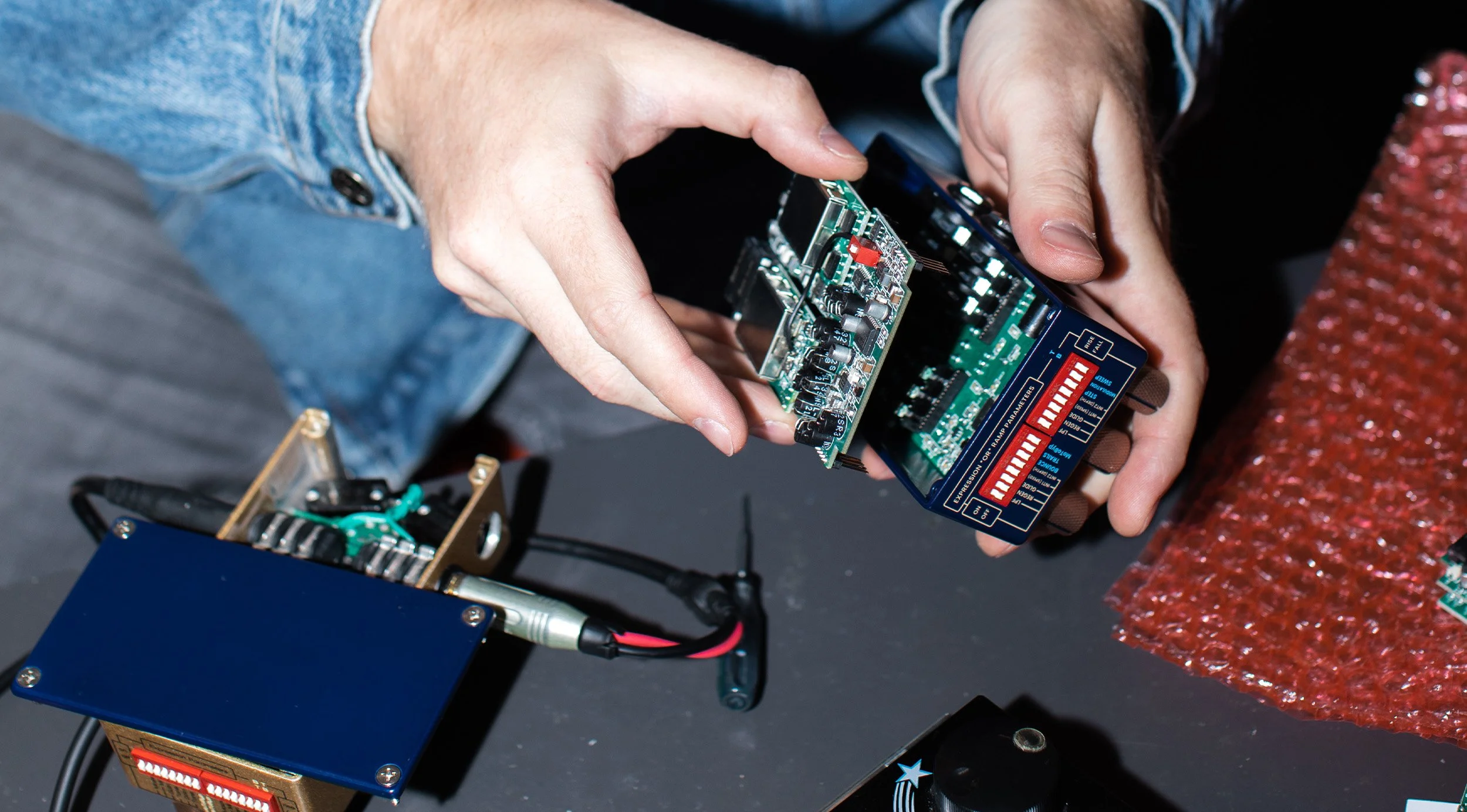 Hands holding a disassembled Thermae effects pedal.