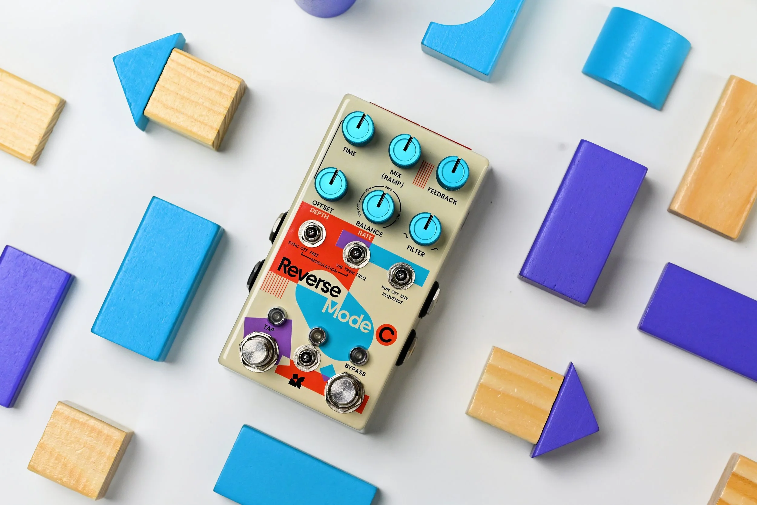 Reverse Mode C effects pedal by Chase Bliss surrounded by toy blocks.