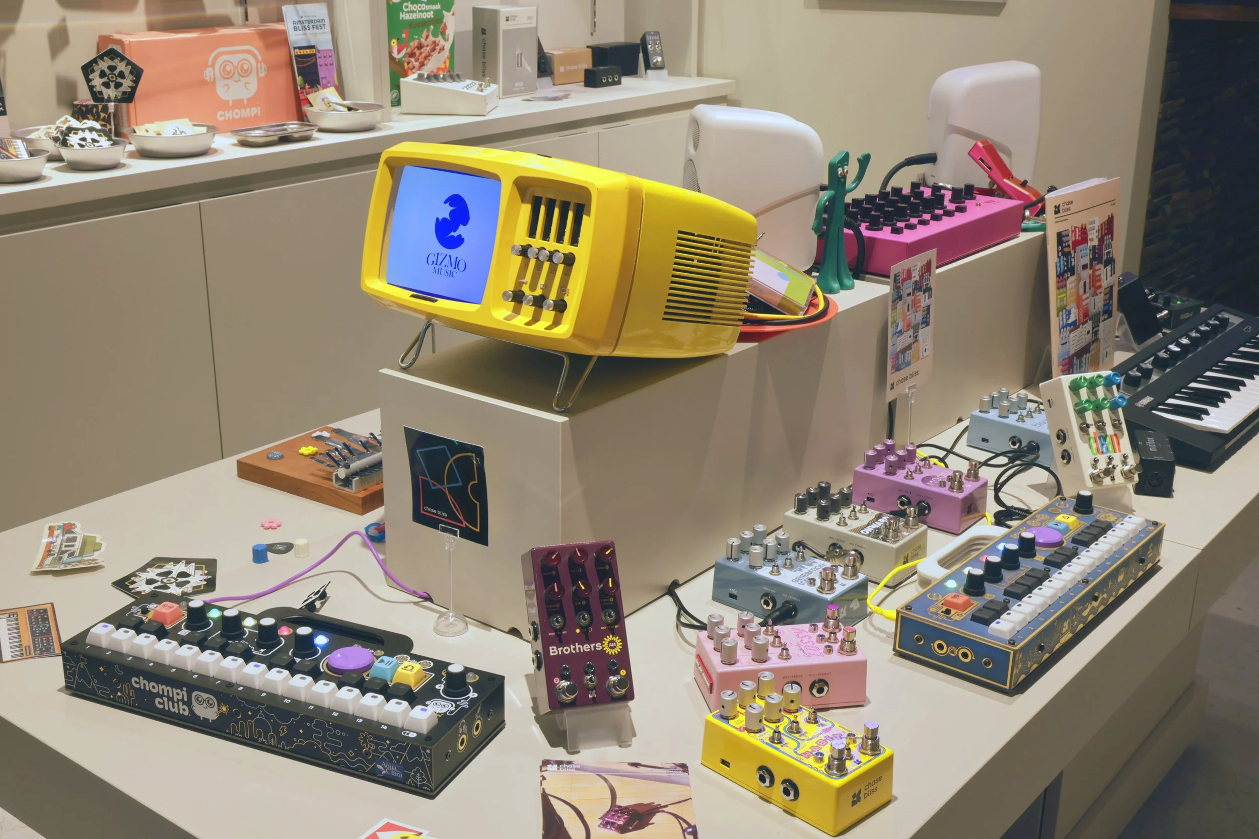 A table filled with Chase Bliss effects pedals and CHOMPI Club samplers.