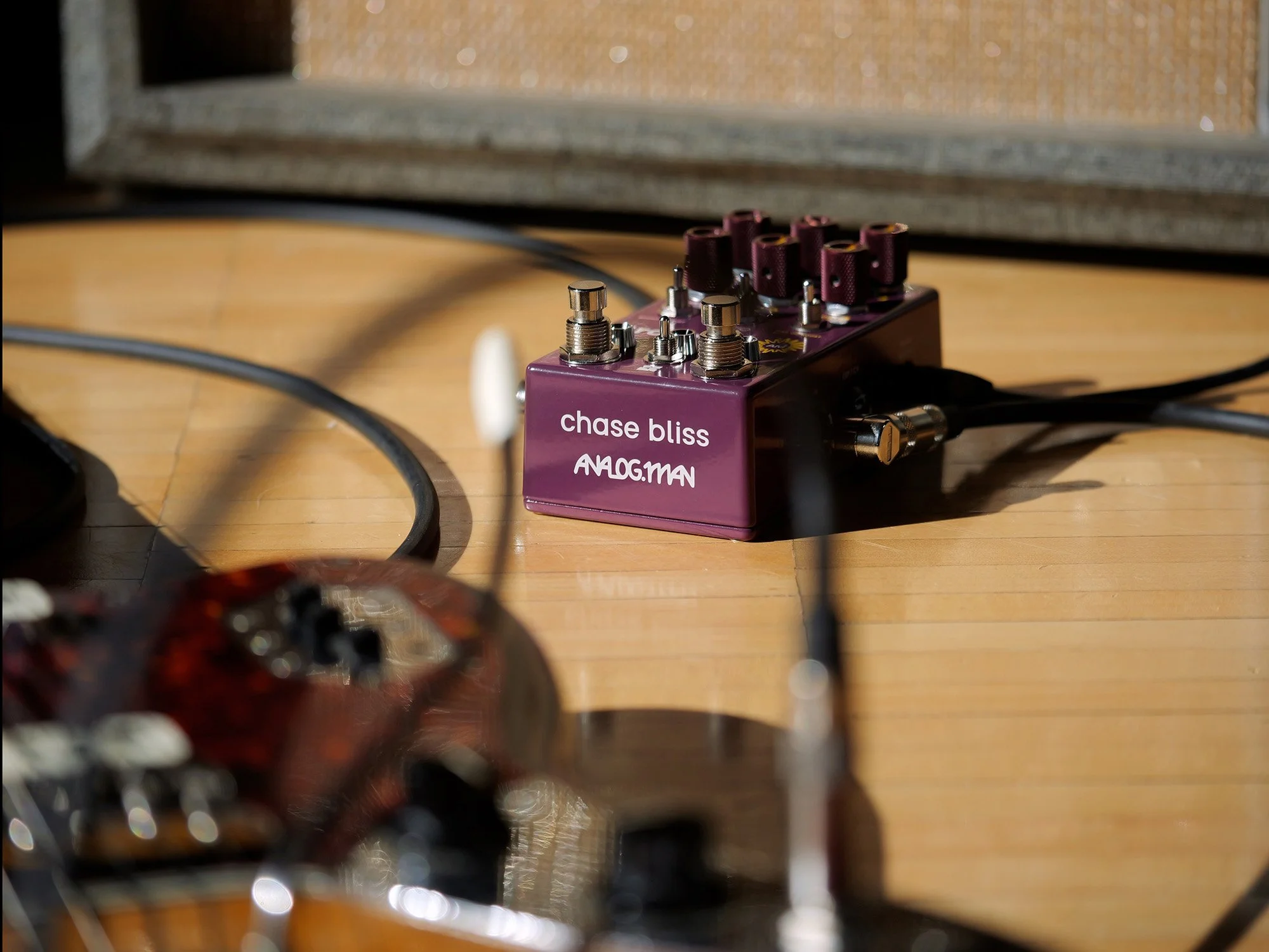 Brothers AM guitar pedal on the floor next to a Fender Jaguar.