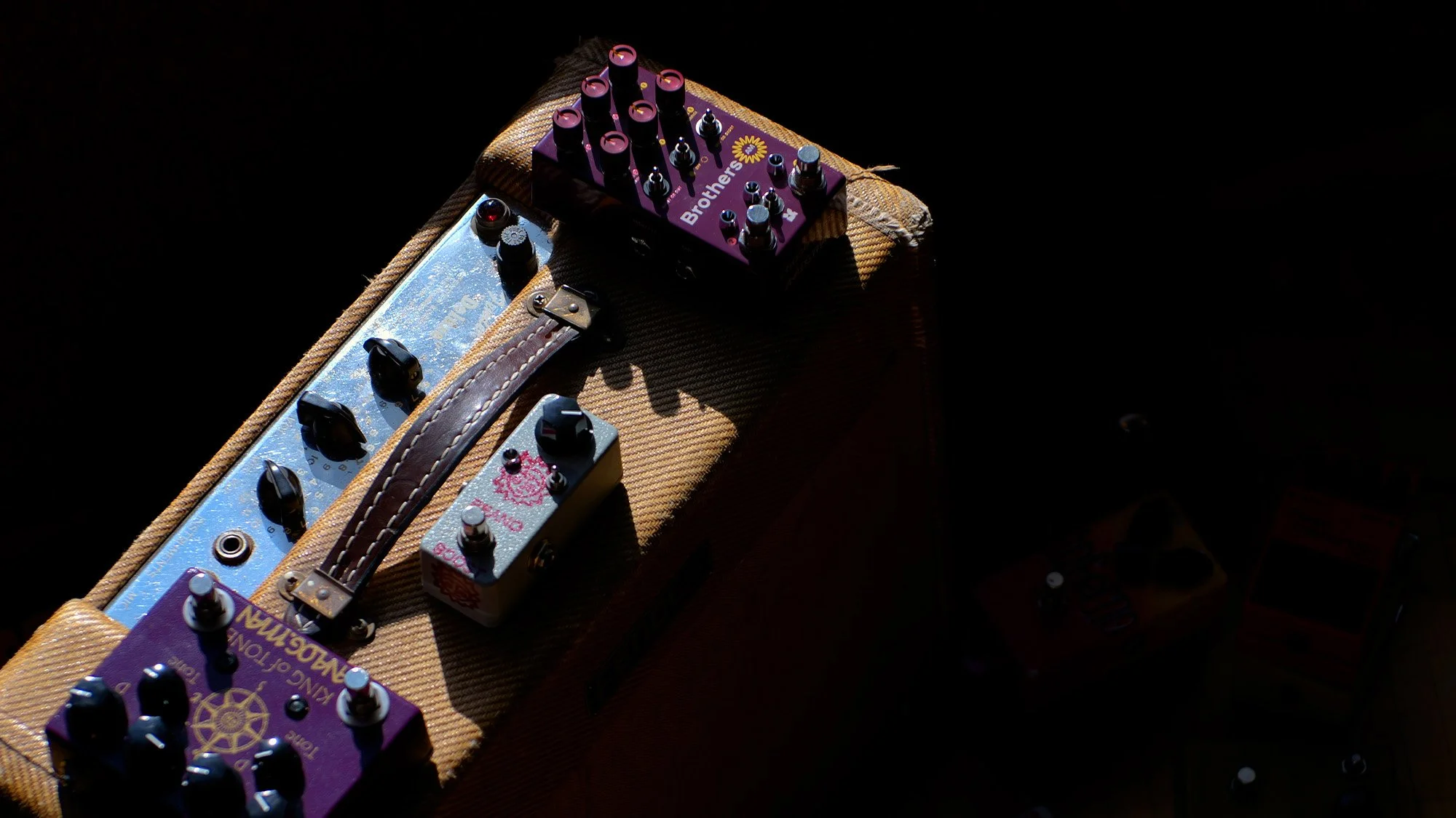 Guitar pedals on top of an amp.