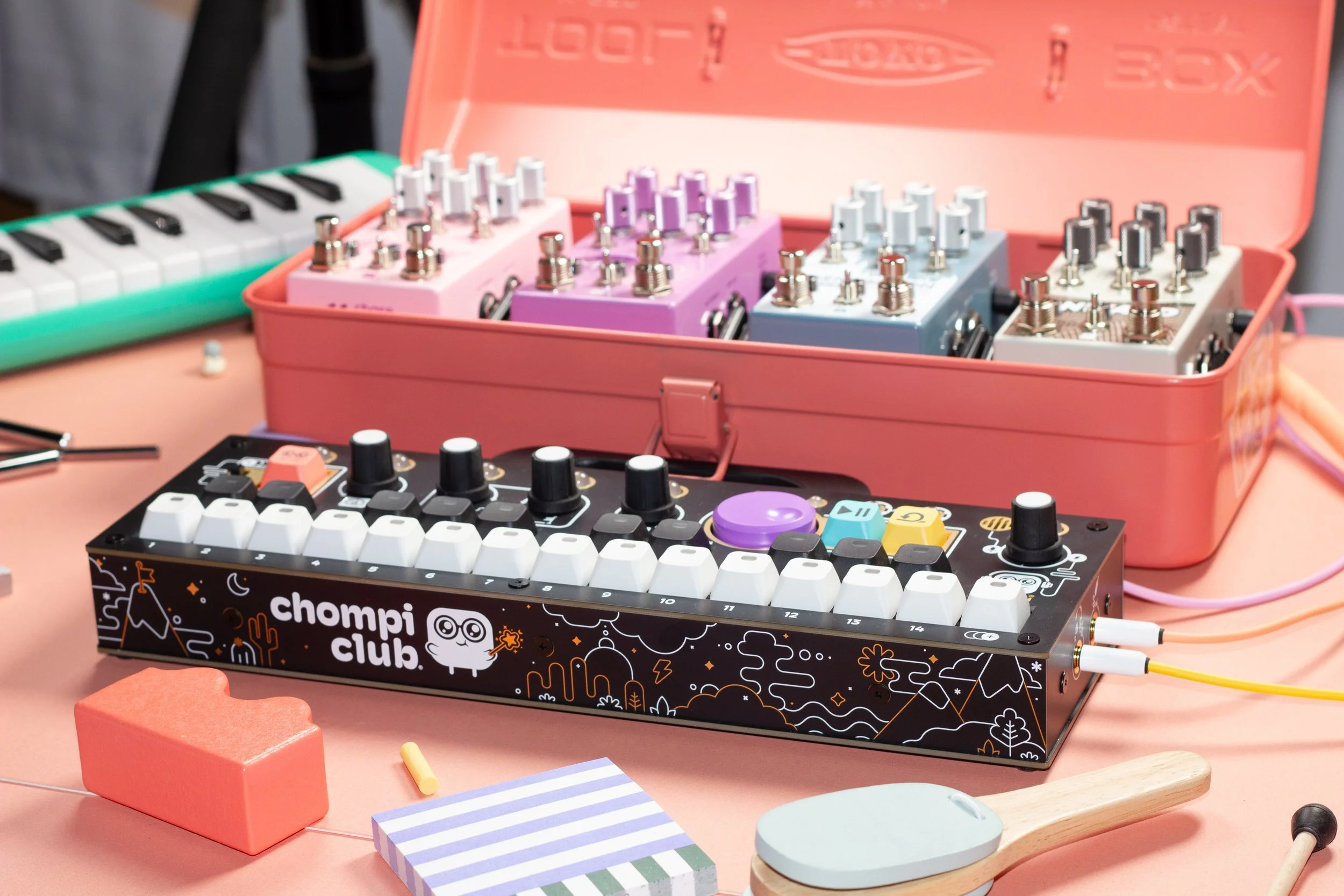 CHOMPI sampler on a pink table surrounded by toys and a toolbox full of Chase Bliss effect pedals.