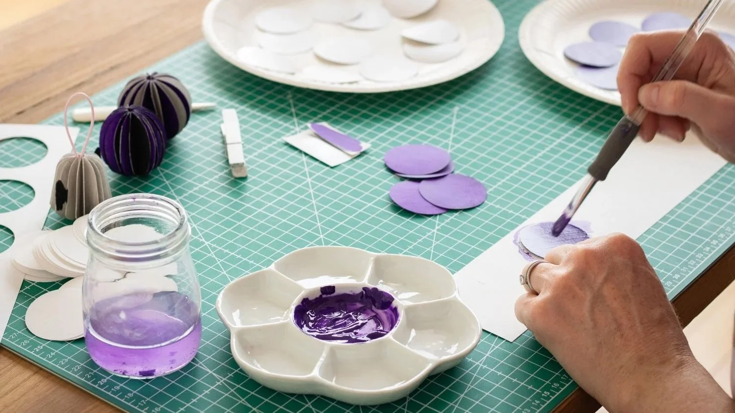 Clare Jones, Paris based illustrator painting and making paper decorations in her studio in Paris
