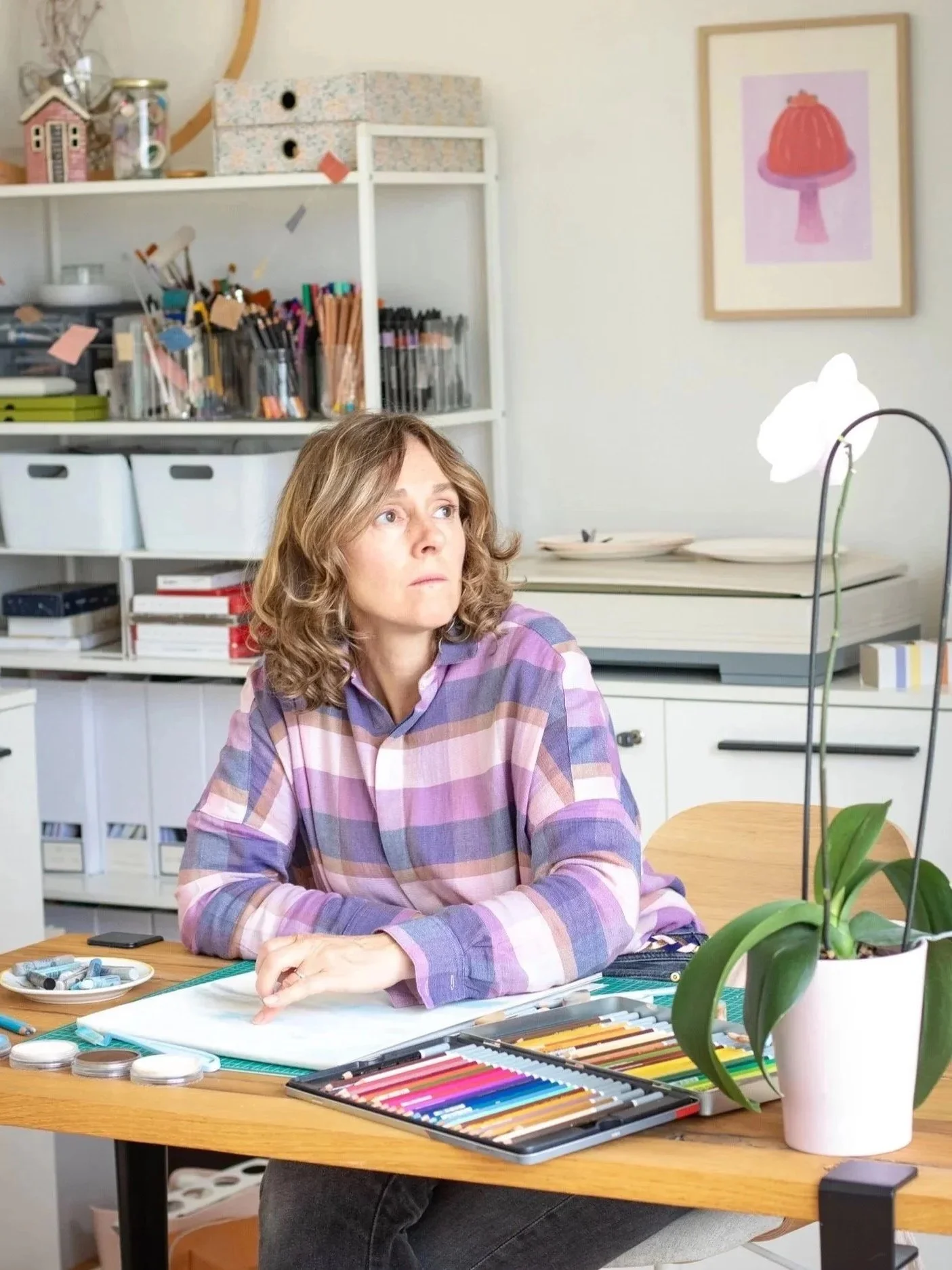 Clare Jones freelance illustrator and graphic designer based in Paris, drawing  at her desk in her studio in Paris