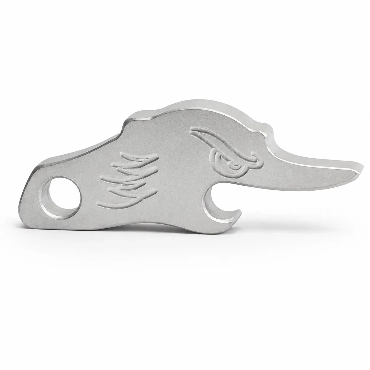 A silver metal key in the shape of a dinosaur with a detailed head, body, and tail, on a white background.