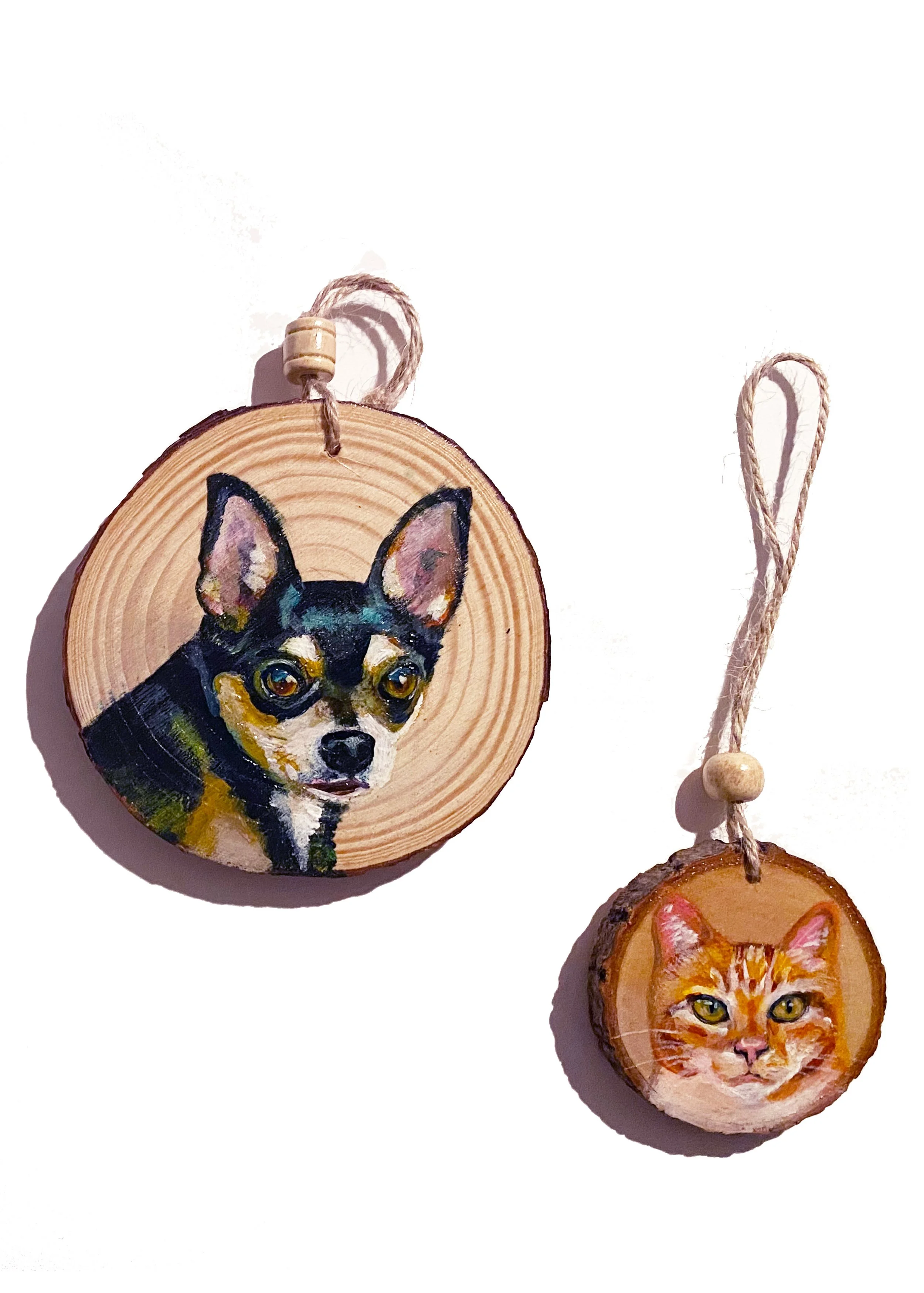 Painted wood slices with portrait of a dog and a cat, hanging with string and beads.